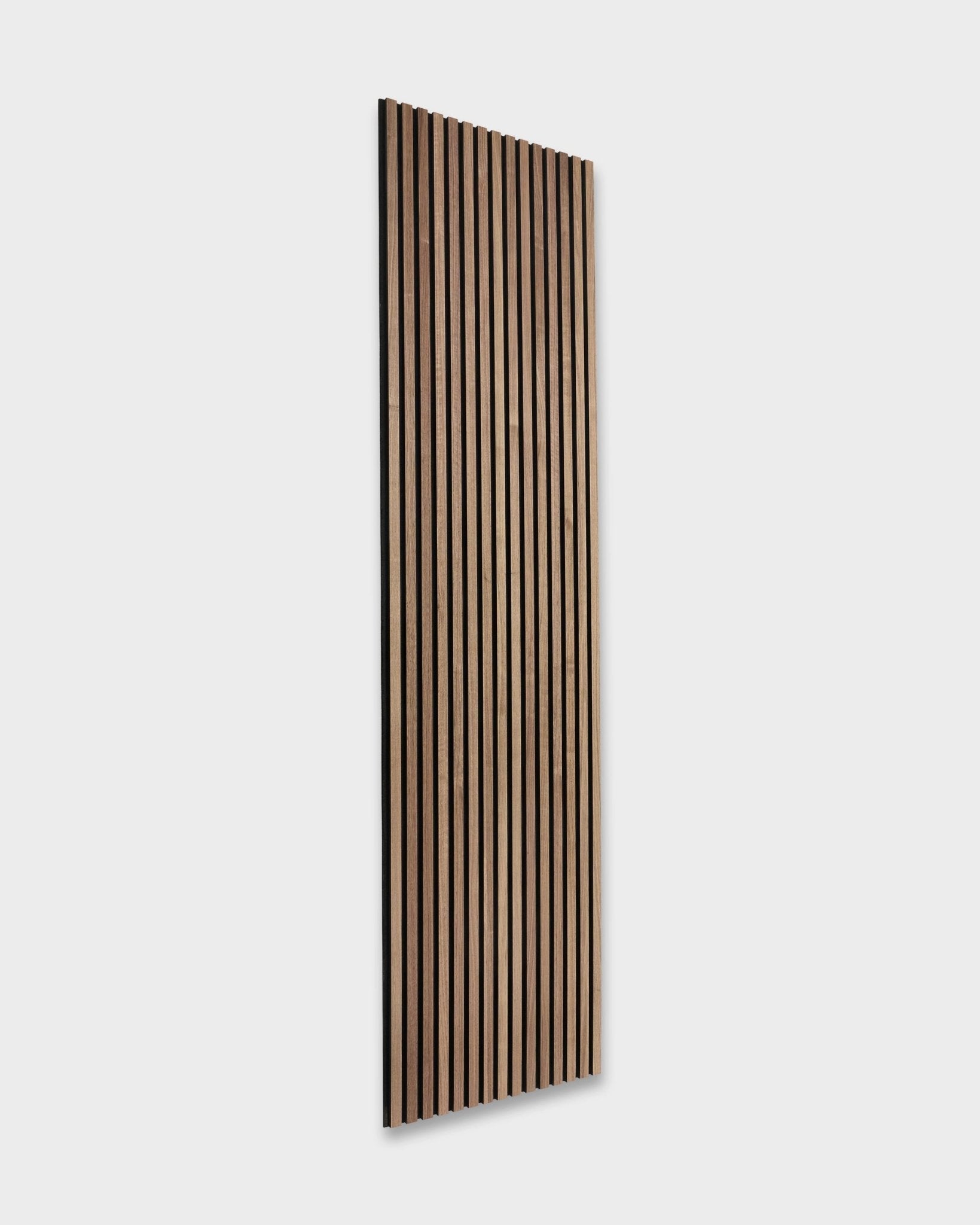WoodUpp Original Akupanel i valnøtt (240x60cm) har mørke brown akustiske spiler montert på en lys grey vegg, og viser et nordisk design inspirert av skandinavisk stil.