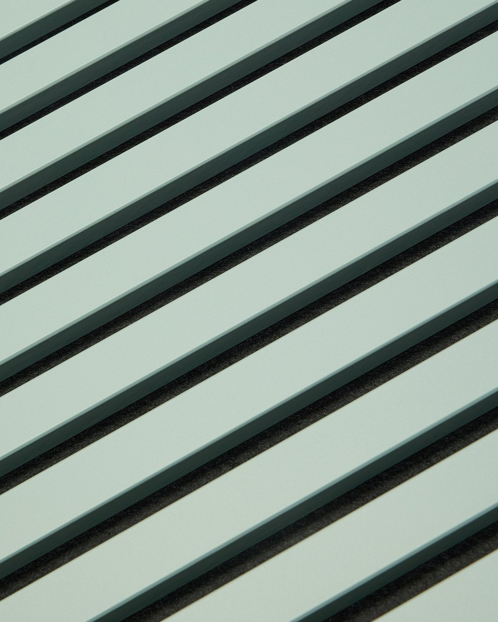Hue | Akupanel / Cloud fra WoodUpp viser lysegrønne akustikkpaneler i tre med vertical spiler og mørke mellomrom, som danner et geometrisk mønster for lydabsorpsjon.