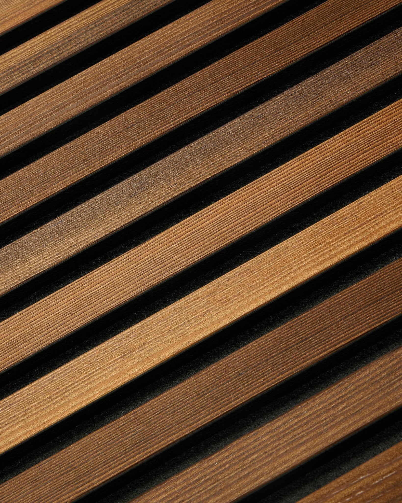 WoodUpp Akupanel Rustic i røkt lerk (240x60 cm) har diagonale brown akustiske spiler som skaper et stripet nordisk uttrykk med subtile skyggelagte detaljer.