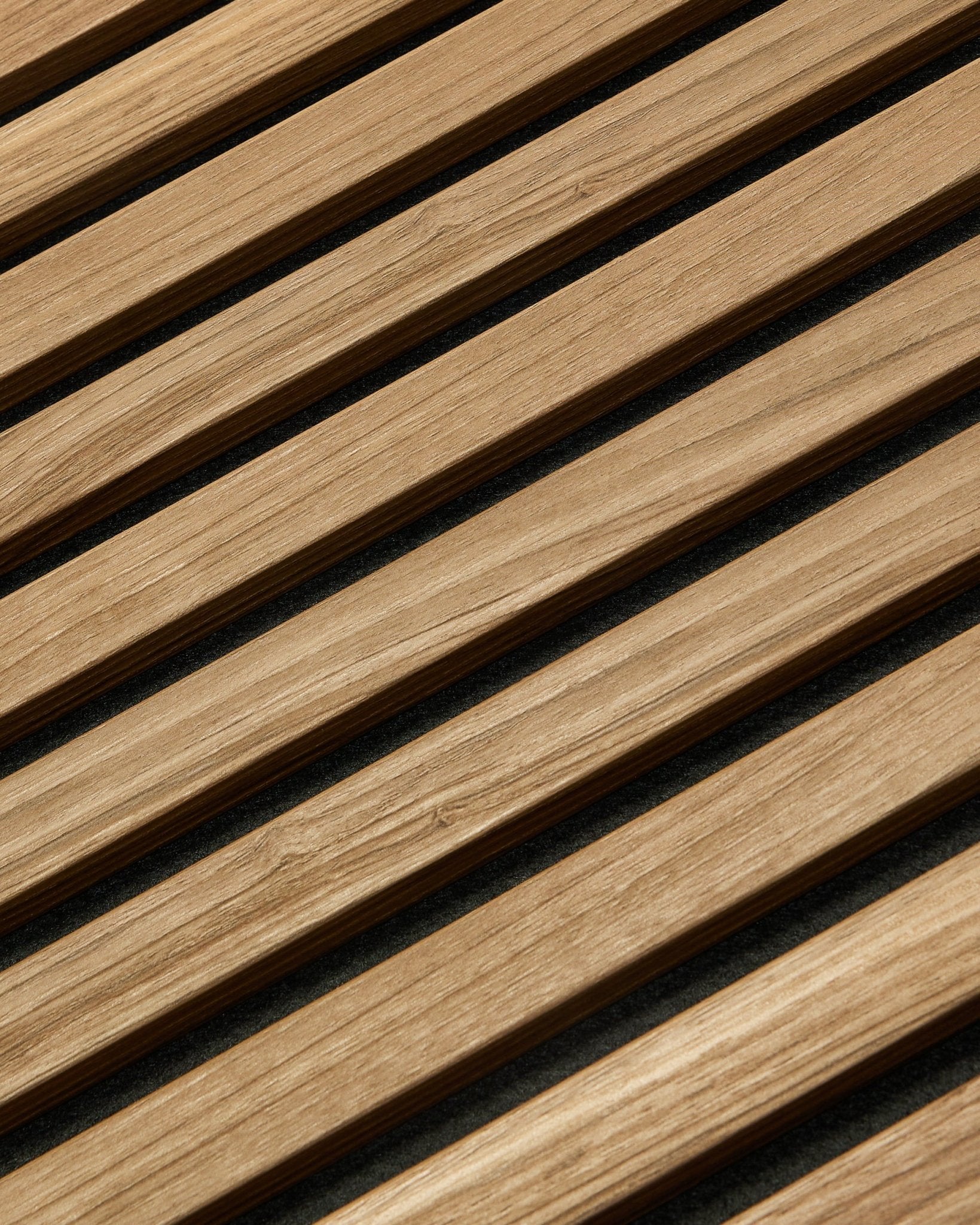 Diagonalt nærbilde av WoodUpp Akupanel Essential Akustikkpanel i English Walnut, 240x60 cm, som viser en jevn finish og mørk bakgrunn mellom hver trespile.