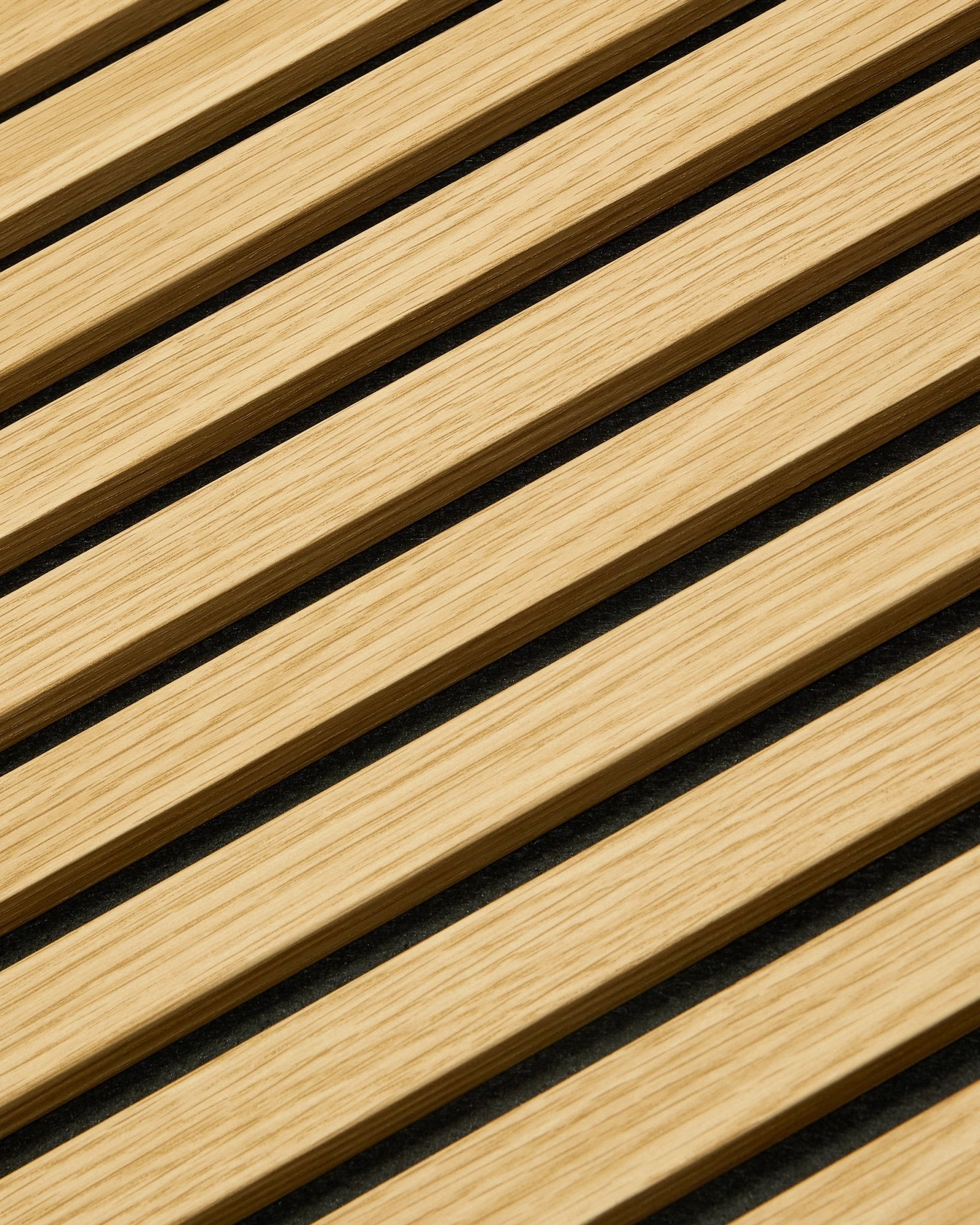 Nærbilde av WoodUpp Akupanel Akustikkpanel i Southern Oak, 240x60 cm, med diagonale spiler og mørke akustiske mellomrom for bedre lydabsorpsjon.