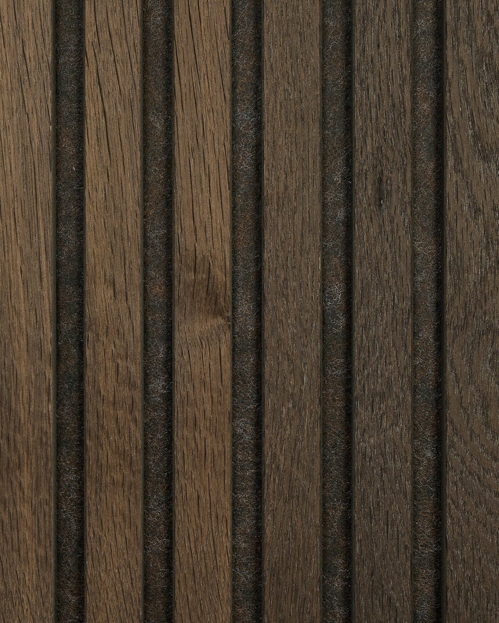 Nærbilde av prøve på Akupanel akustisk trepanel i Smoked Oak fra WoodUpp, med naturlig brown-åretegning, vertical spor og jevnt fordelte mørke linjer.