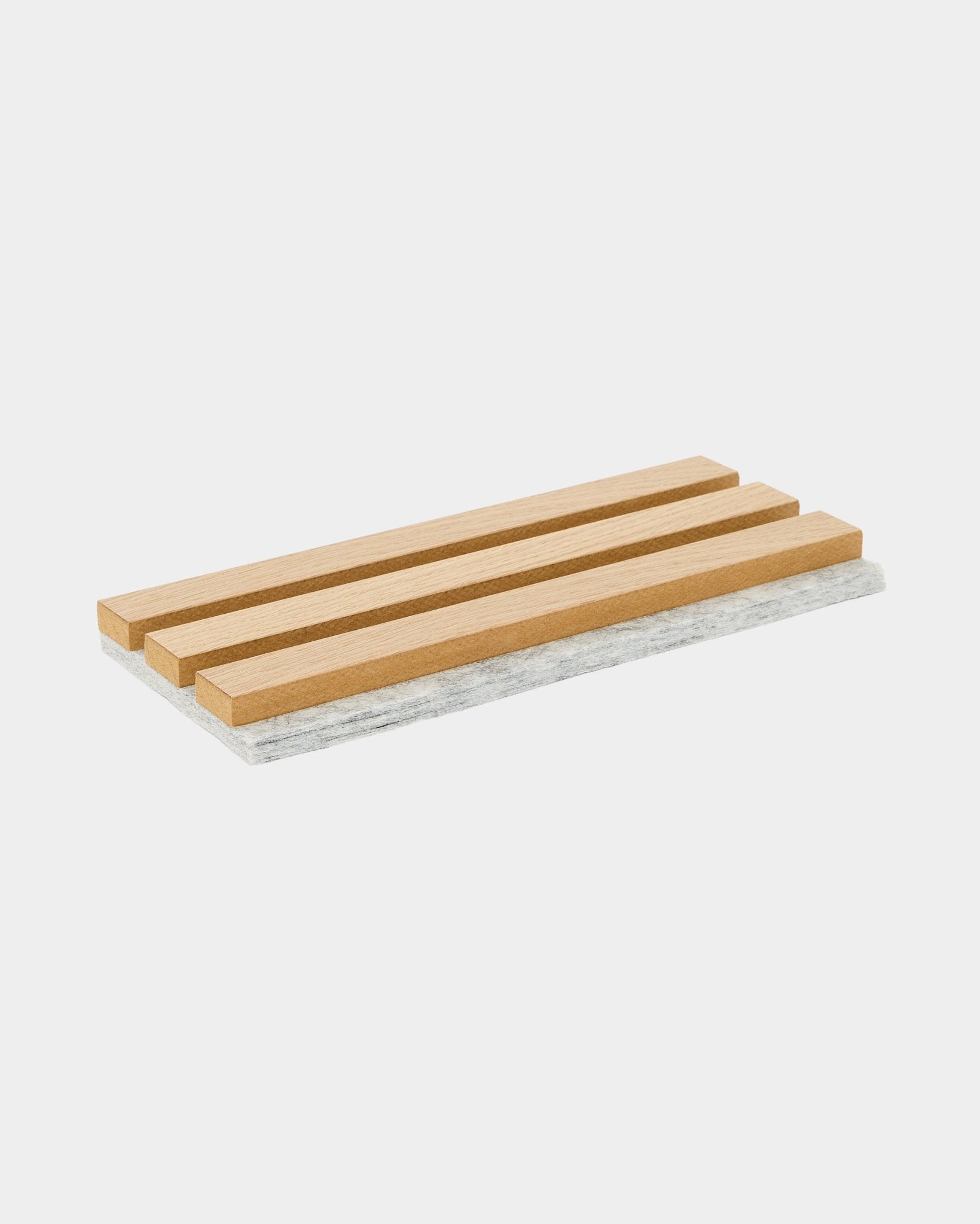 WoodUpp Akupanel prøvebrikke med klassiske eikespiler og grå filt på baksiden, laget for å beskytte overflater og vise frem nordisk akustisk materiale.