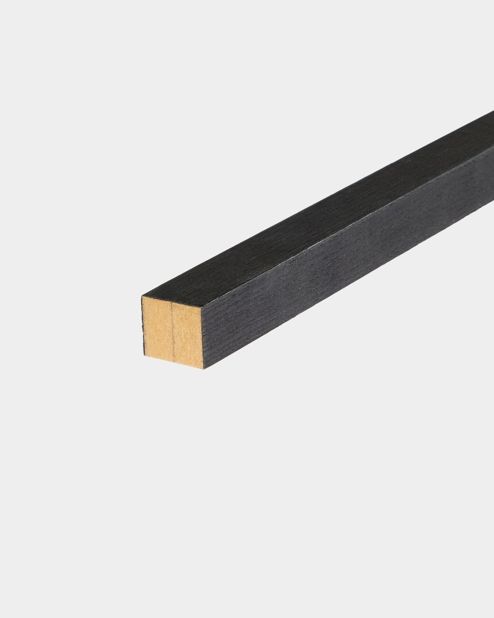 WoodUpp Black endelamell i ask, 2,2 cm, designet for Akupanel Akustikkpanel Montering, plassert på en hvit overflate med én ubehandlet ende.