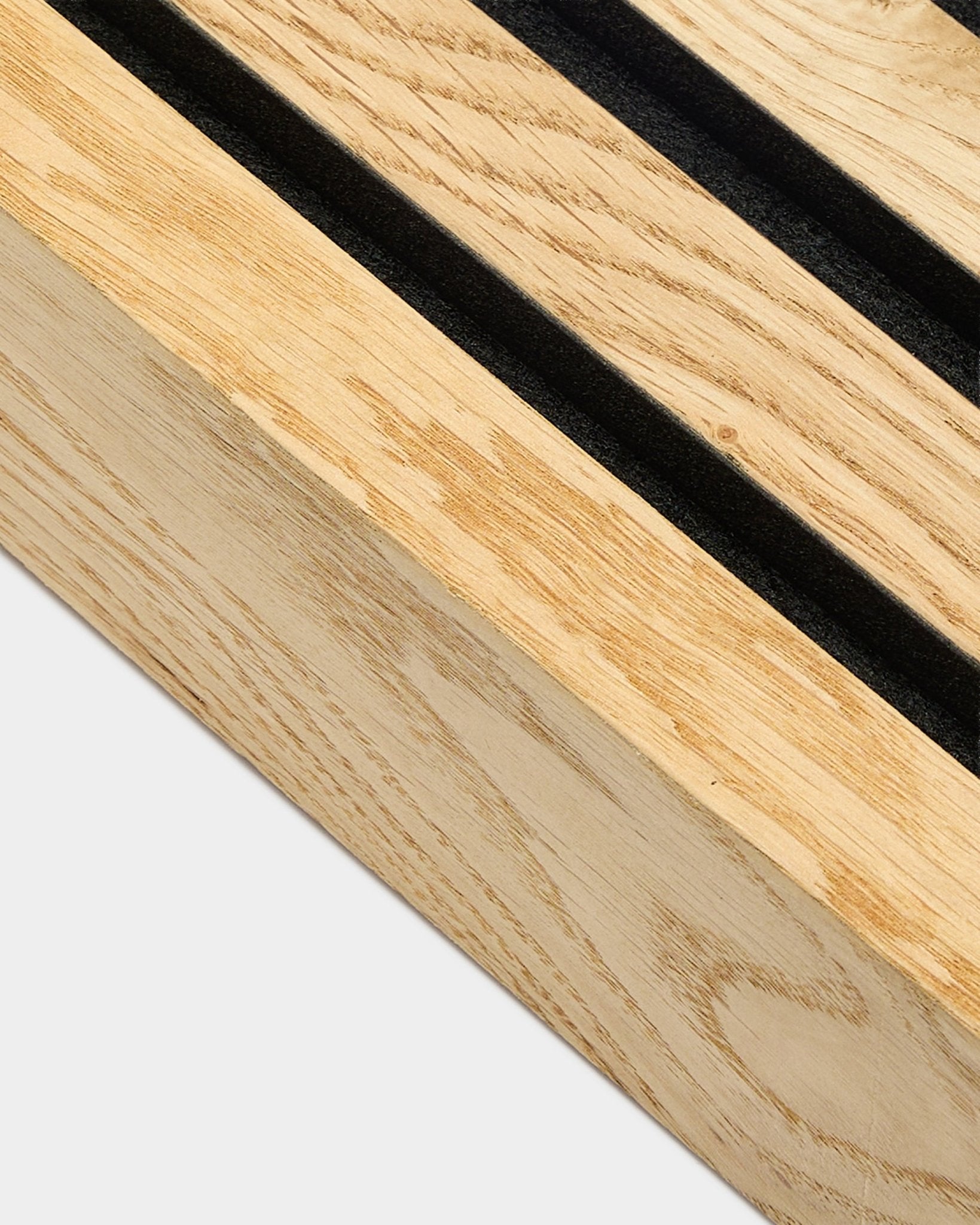 Nærbilde av en WoodUpp Akupanel endelamell i Rustic Natural Oak, 6,7 cm, med parallelle spor for black og en MDF-ramme for akustisk veggMontering.
