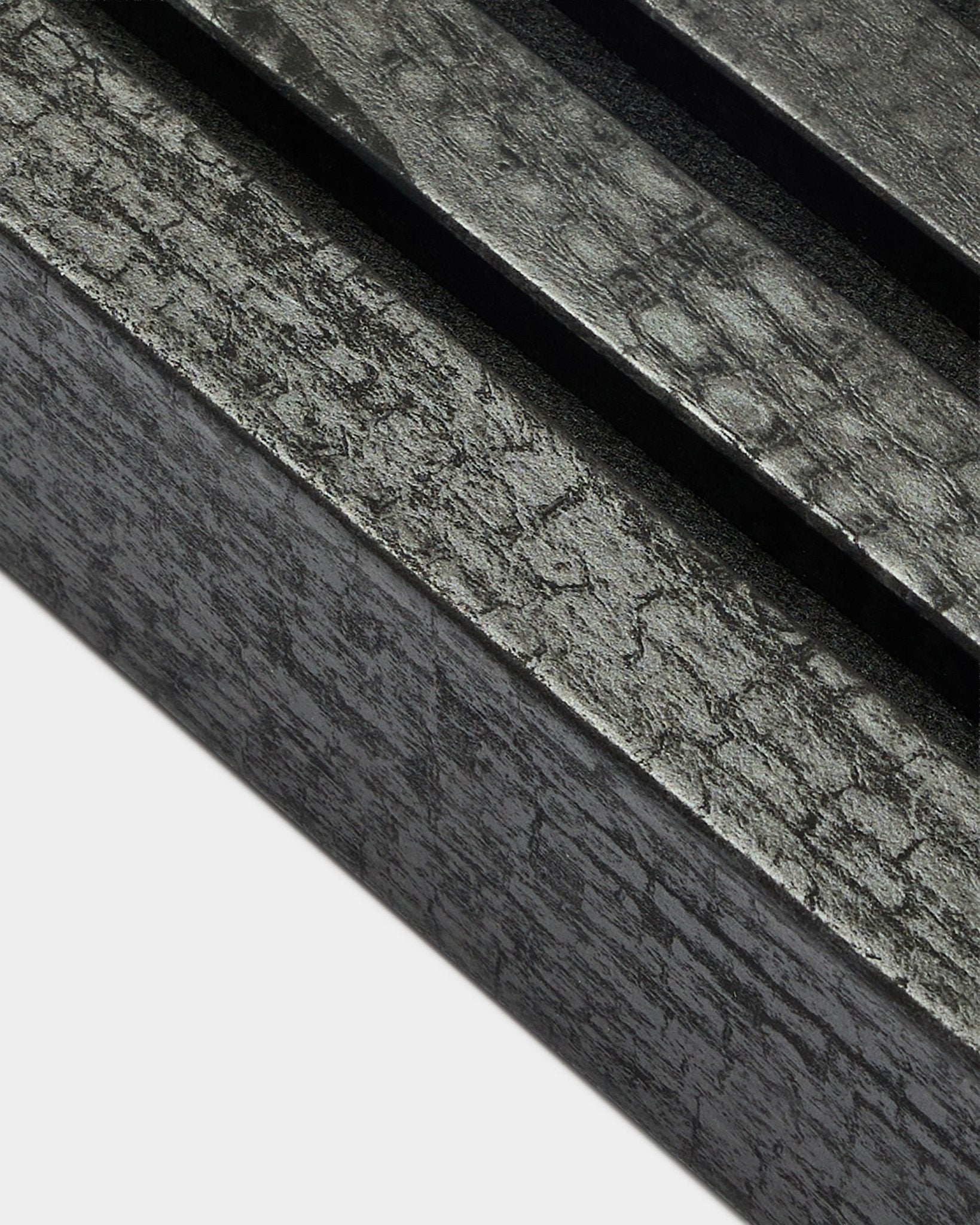 Nærbilde av WoodUpp Akupanel endelamell i Charcoal, 6,7 cm bred, med parallelle akustiske spiler og en tydelig trestruktur.