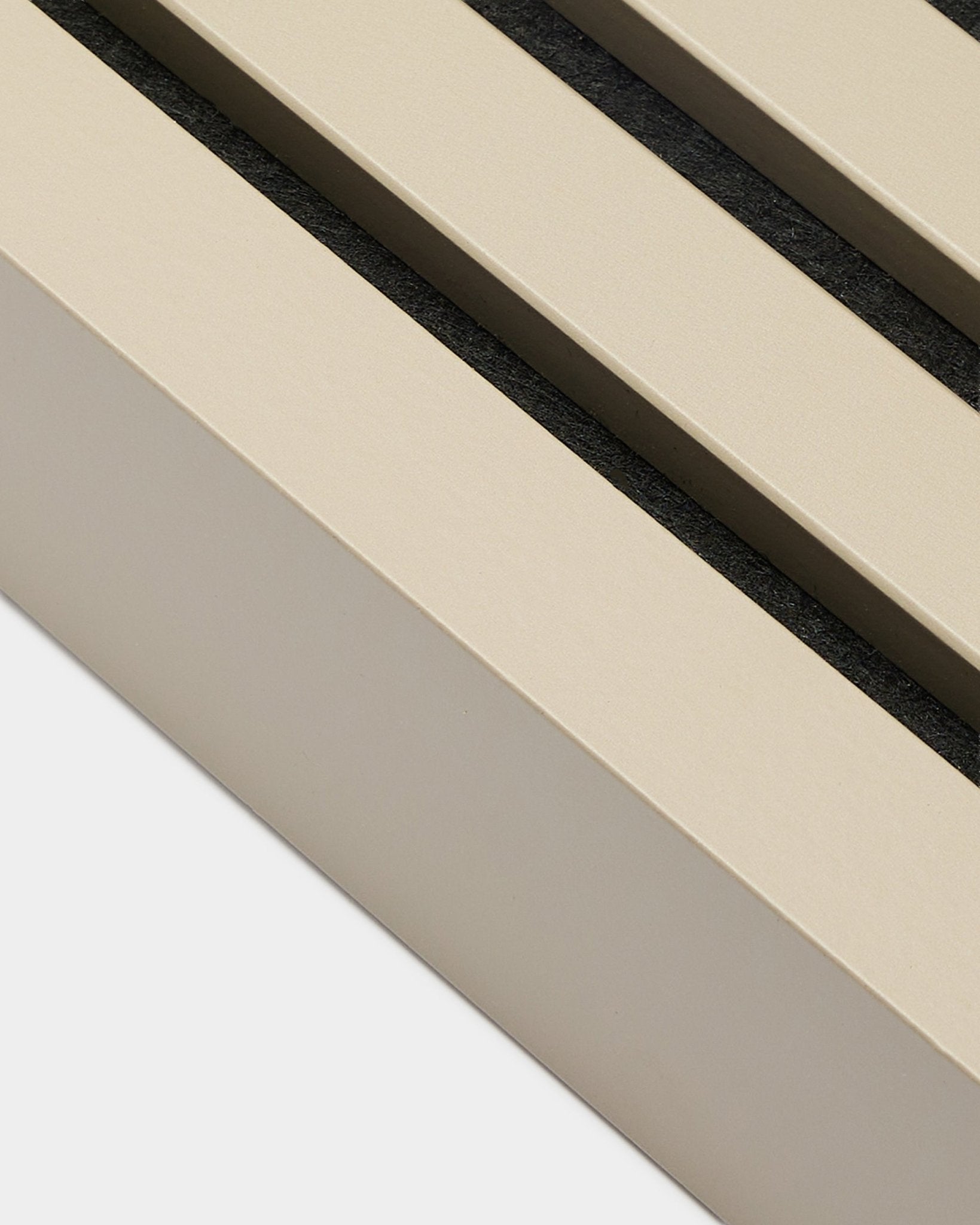 Nærbilde av WoodUpp End Lamella i Stone-finish, 6,7 cm bred—Montering tilbehør for MDF-rammer eller Akupanel akustiske paneler. Beige panelspiler med black mellomrom.