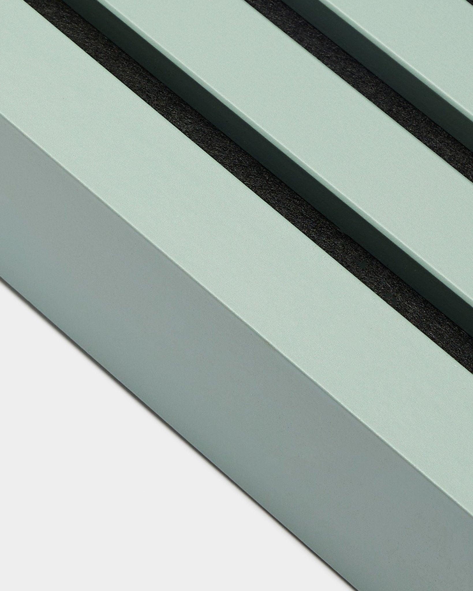 Nærbilde av WoodUpp Akupanel Montering-tilbehør: endelamell i Cloud, 6,7 cm bred, mintgrønn MDF-ramme med to black spor på hvit bakgrunn.
