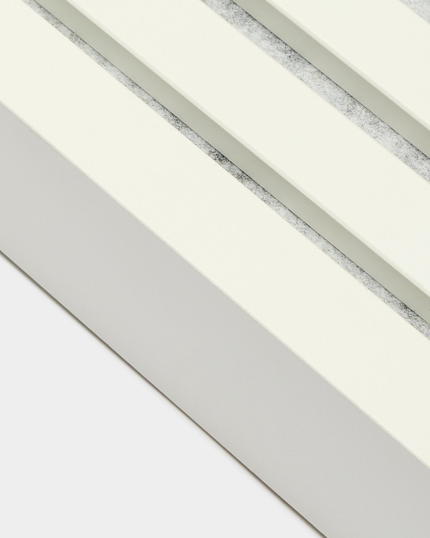 Nærbilde av WoodUpp avslutningslamell i Snow, 6,7 cm bred, med MDF-ramme, doble spor og en teksturert grey-finish for Akupanel Akustikkpanel Montering.