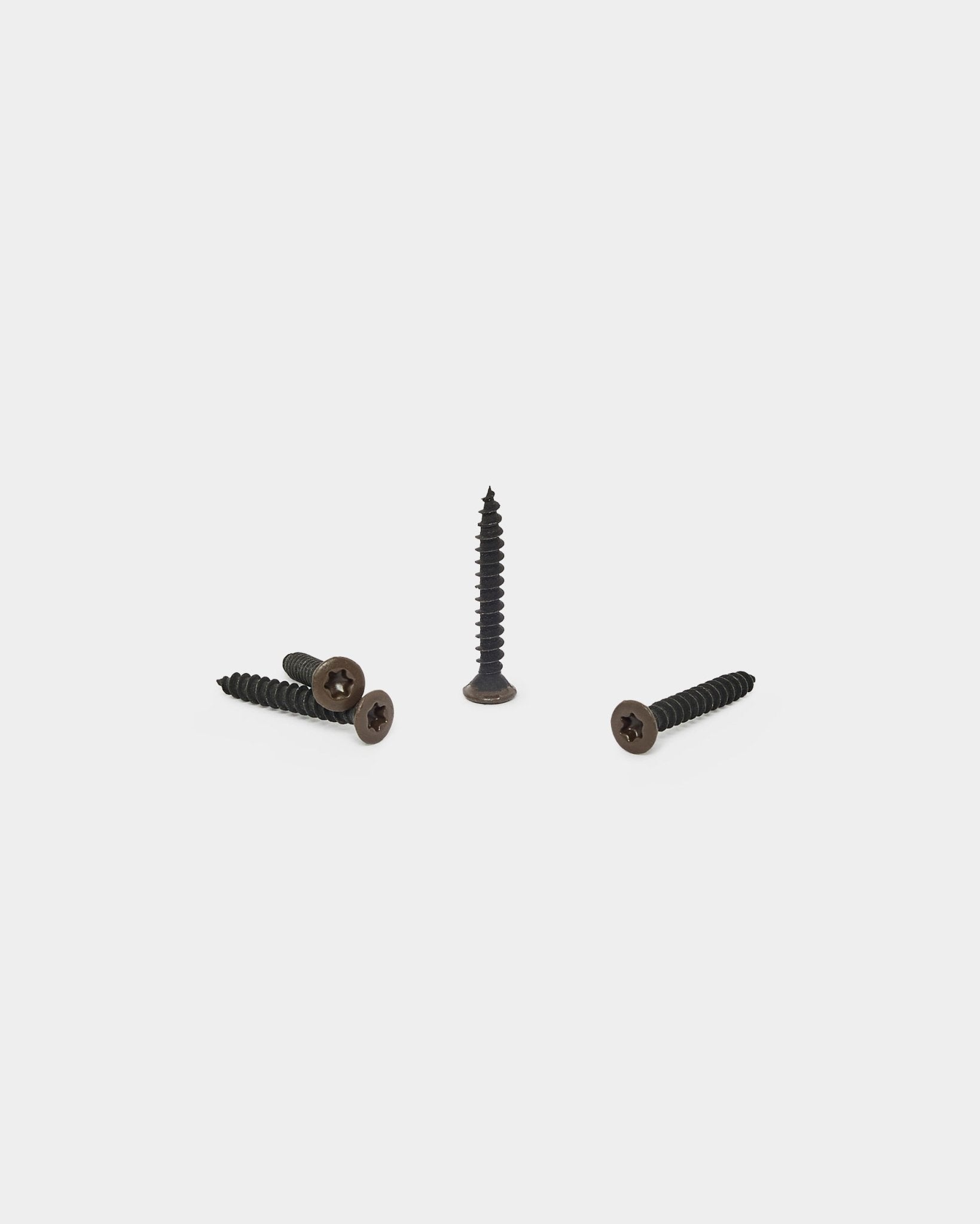Tre bronzed brown WoodUpp-skruer, én stående og to liggende, laget for å feste filt-bakside til Akupanel akustikkpaneler. Pakke med 100.