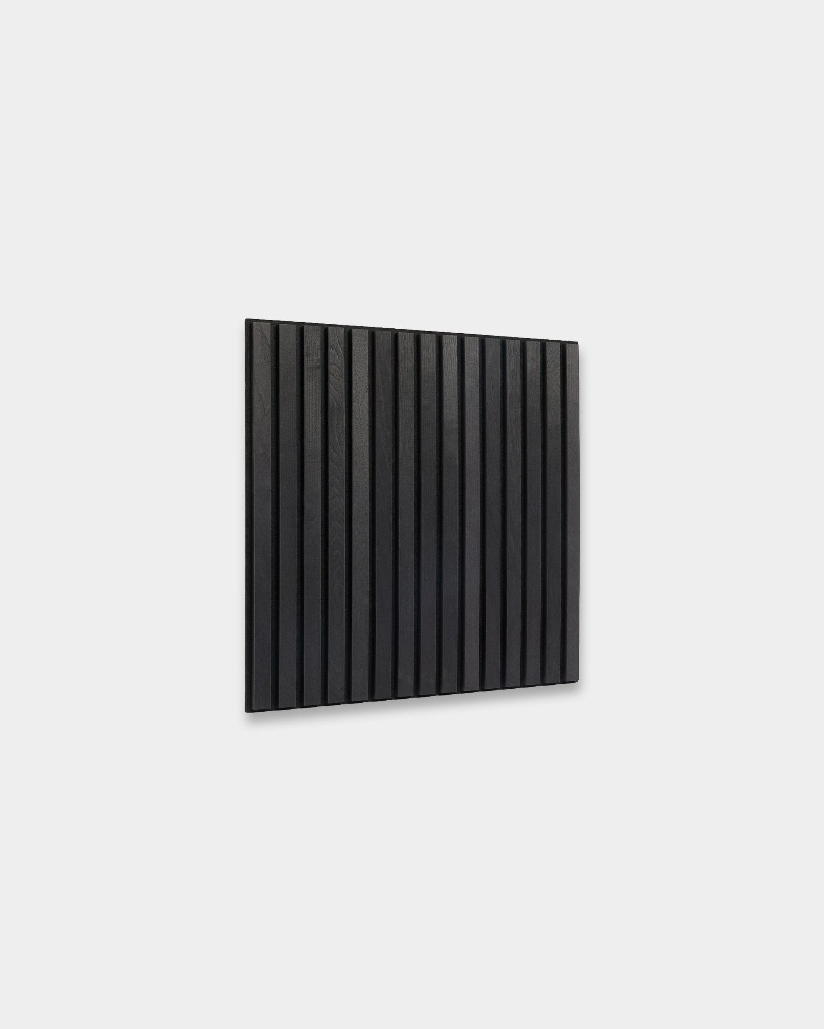 WoodUpp Akupixel Black Ask Akustikkpanel (60x60 cm) med vertical trespiler montert på en lys grå vegg, som viser minimalistisk skandinavisk design.