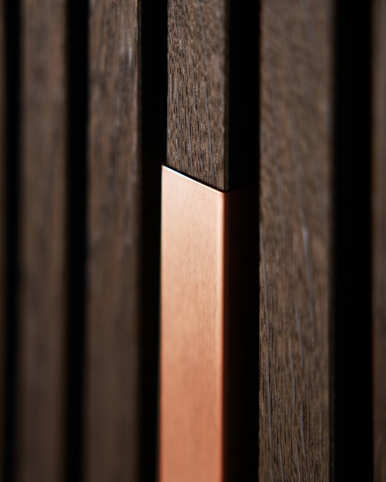 Nærbilde av WoodUpp Akupanel Liva | Cover i Copper, 60 cm, som viser vertical akustiske trespiler med copper detalj som gir tekstur og kontrast.