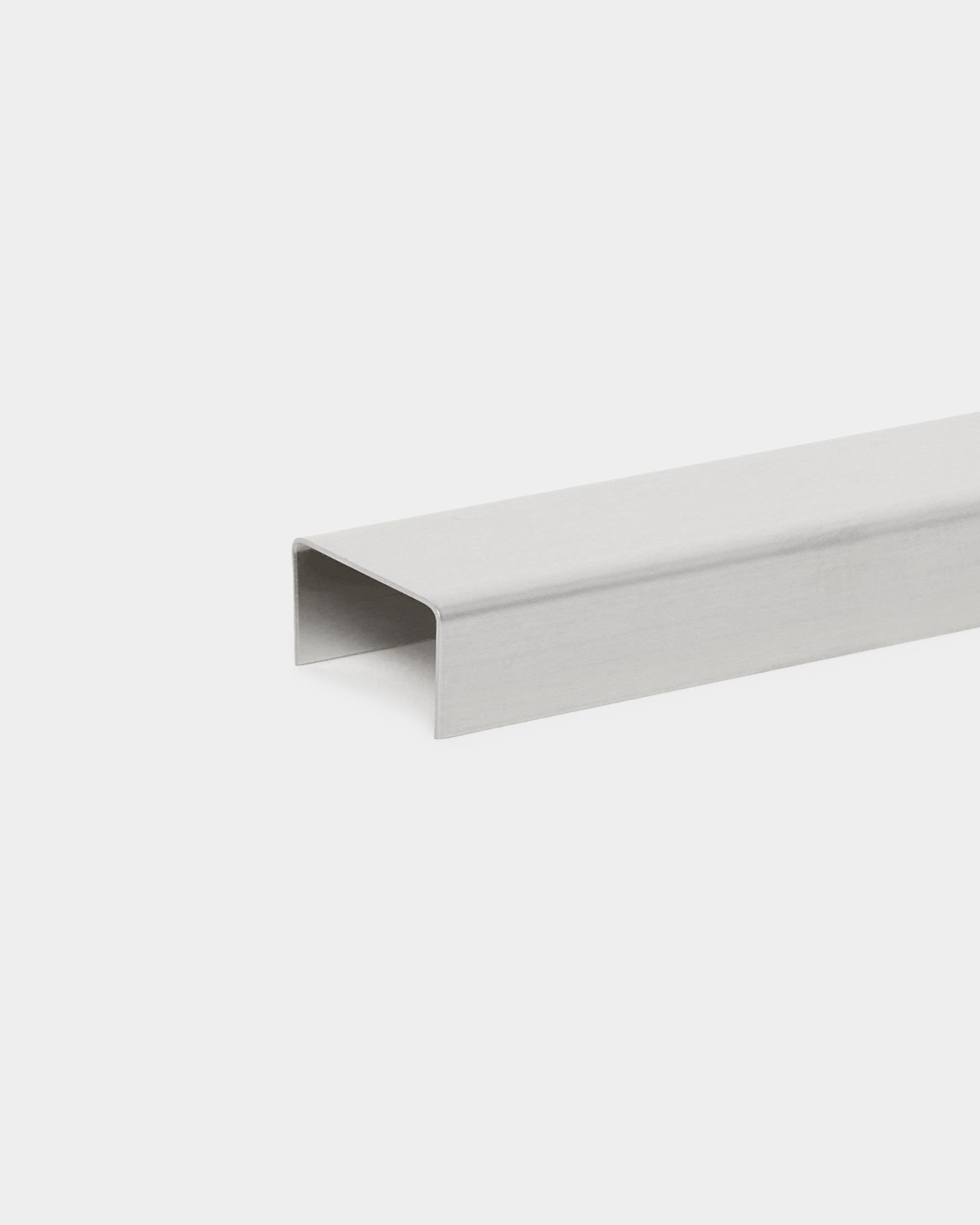Liva Cover fra WoodUpp: 60 cm polert steel U-formet metallkanaltilbehør, utformet for bruk med Akupanel akustikkpaneler, vist mot en hvit bakgrunn.
