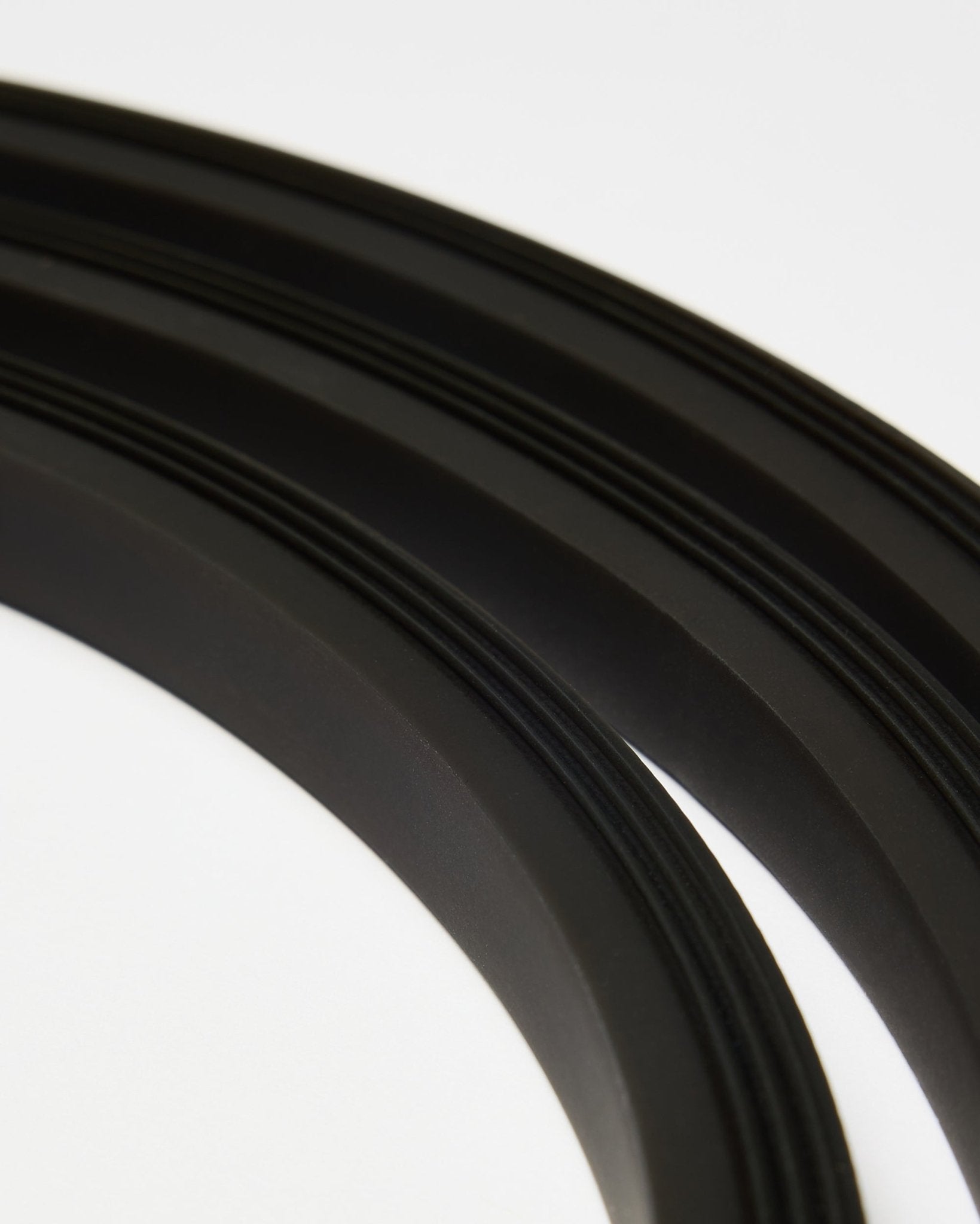 Nærbilde av black Lumi LED-lyslisten fra WoodUpp (300 cm), arrangert i buede linjer på hvitt, som kompletterer den minimalistiske Akupanel Akustikkpanel stilen.
