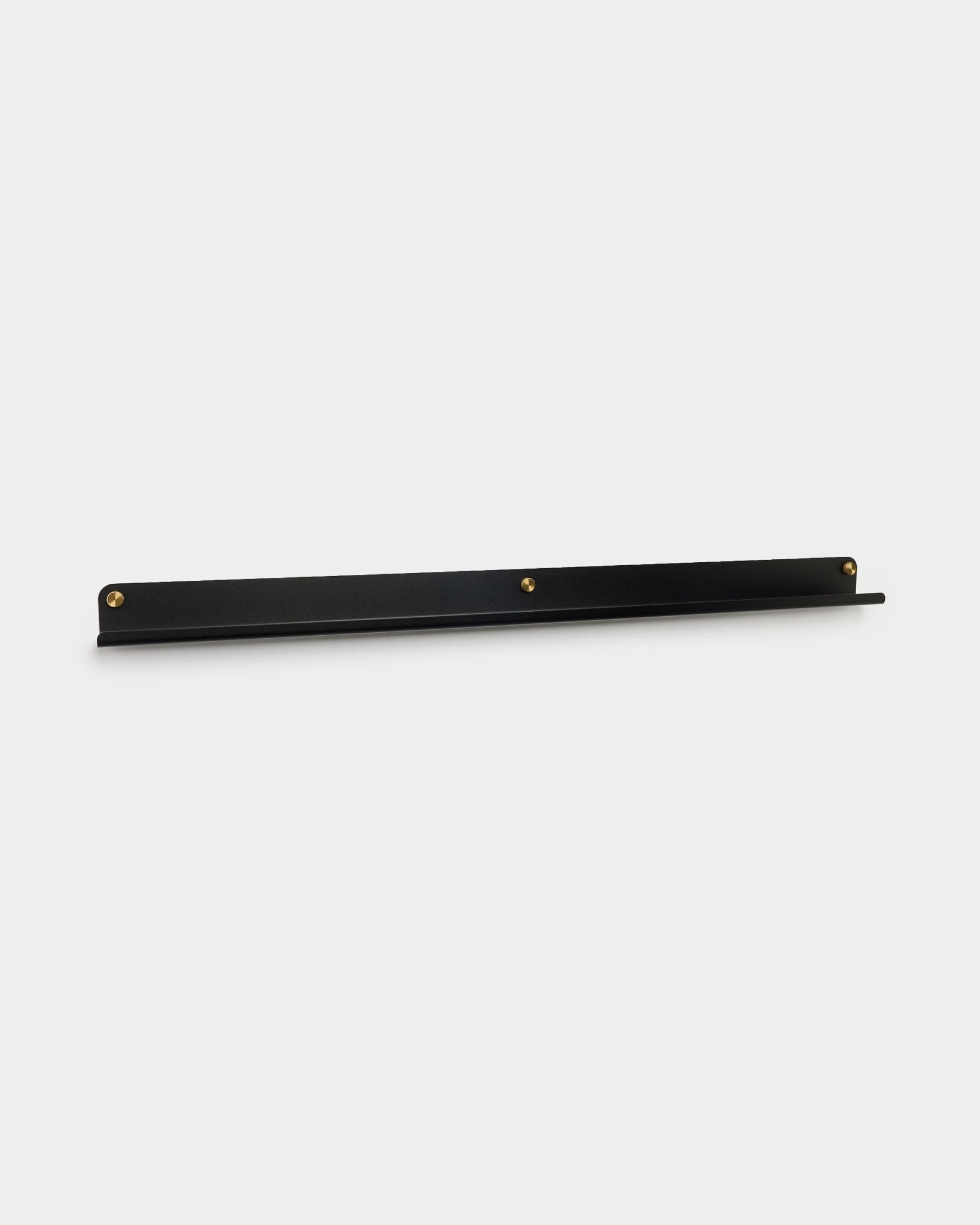 Den Norr smale hyllen i black fra WoodUpp, 115,9 cm, veggmontert med tre brass tommelskruer, vist mot en enkel hvit bakgrunn.
