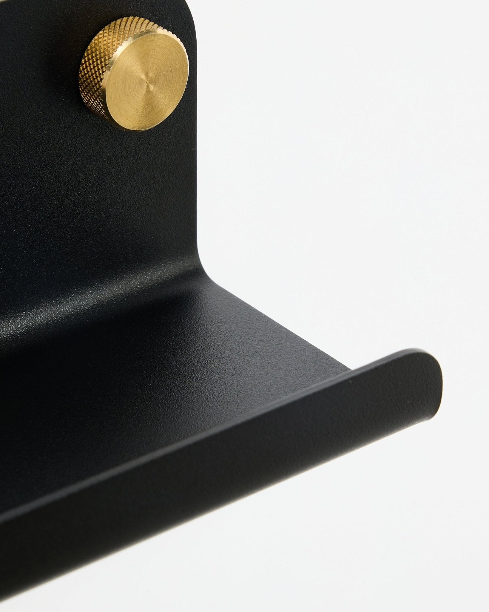 Nærbilde av WoodUpp Norr Smal hylle i black, 75,9 cm, med en teksturert gullknott, vist mot en hvit bakgrunn.