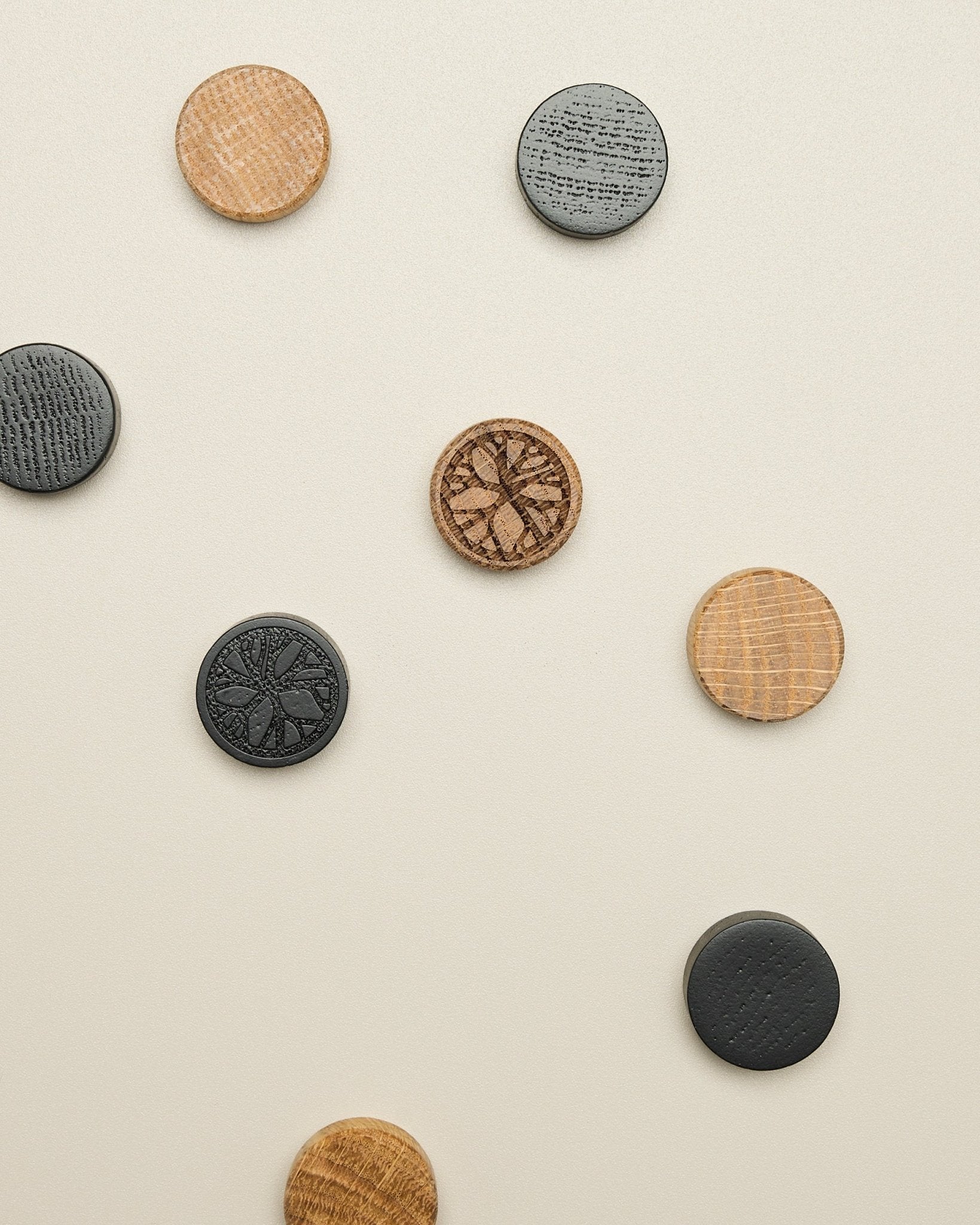 Norr magnetsett fra WoodUpp består av fire skiver med mønster i natural oak og black, pent plassert på en lys beige overflate; tilbehør til Akupanel.