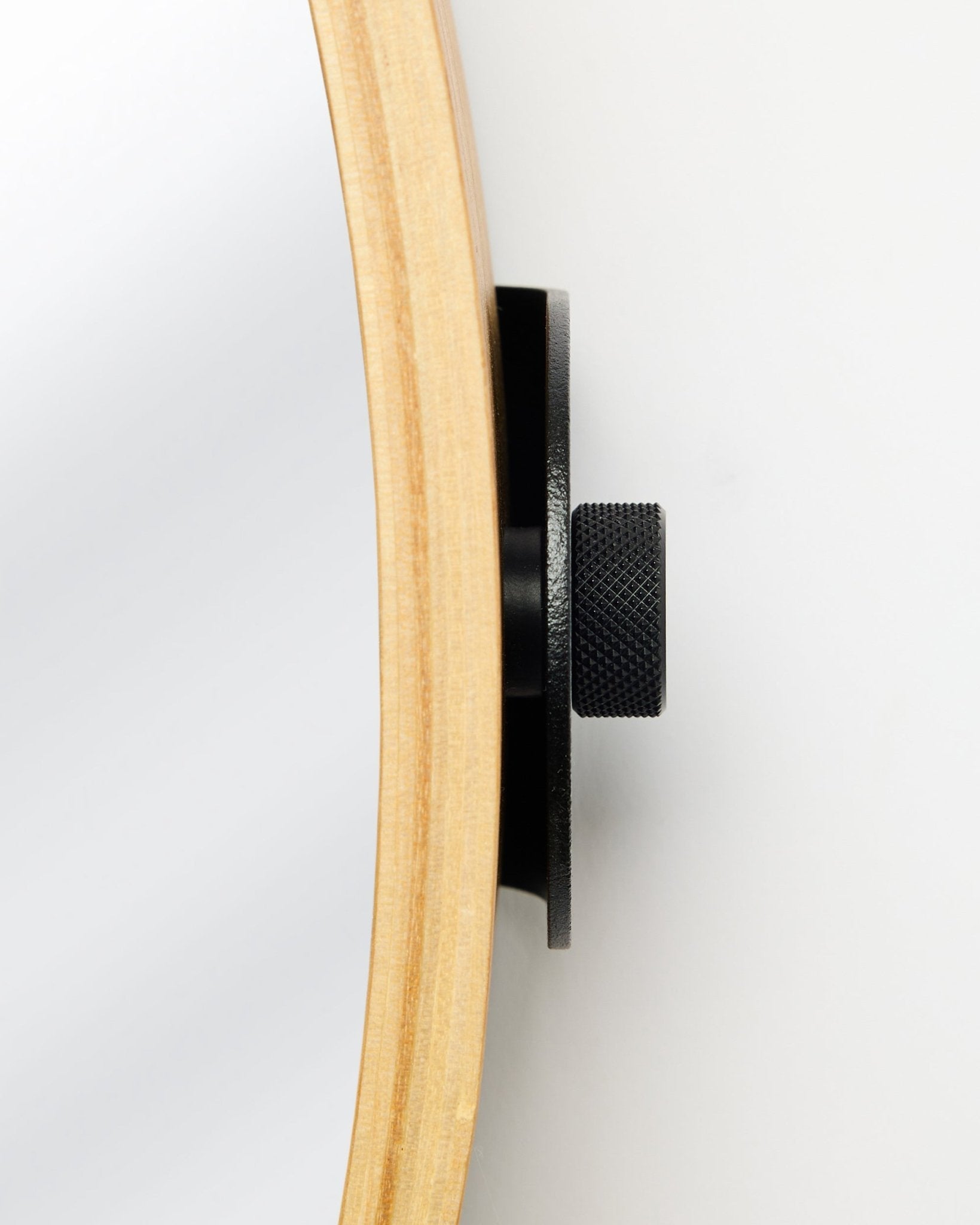 Nært sidebilde av WoodUpp Linn | Mirror i Natural Oak, med en rund ramme i eik og metallknott i black, et tilbehør til akustiske trepaneler.