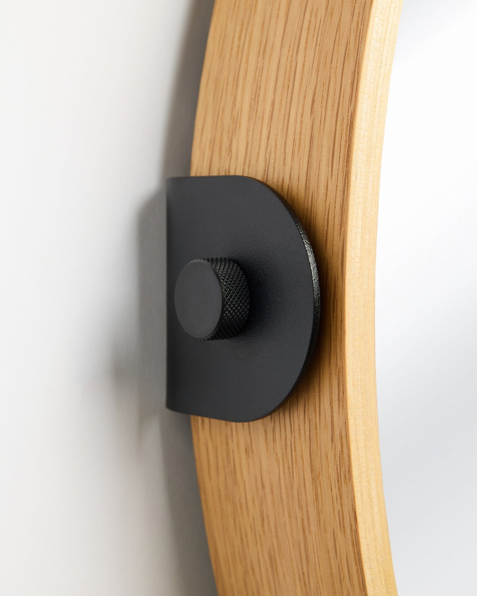 Detalj av WoodUpp Linn Mirror i Natural Oak, en Akustikkpanel montert på veggen med en metallbrakett i black og rund knott.