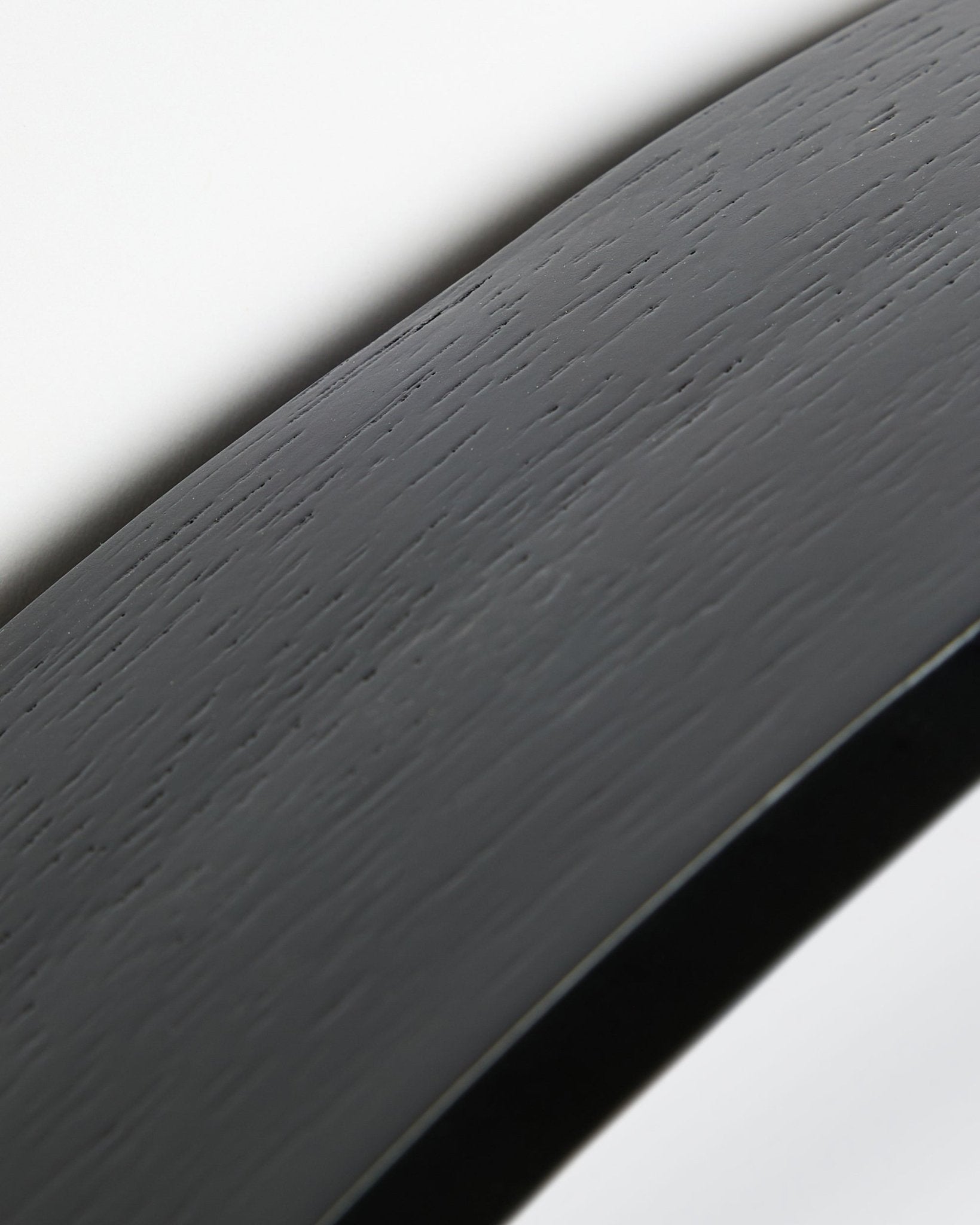Nærbilde av Linn | Mirror / Black Oak Akustikkpanel fra WoodUpp, med en buet black oak overflate og ramme mot en hvit bakgrunn.