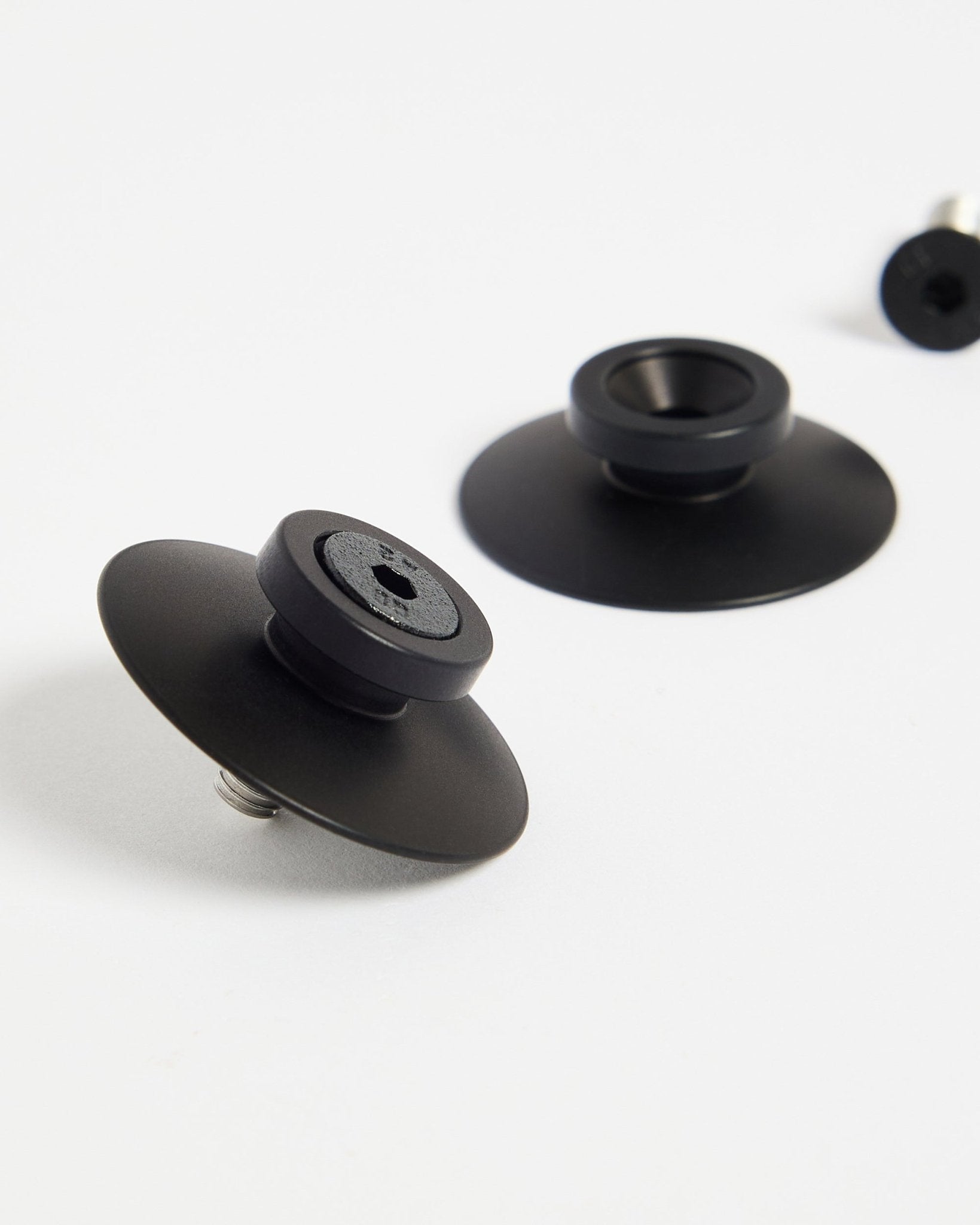 To black aluminium WoodUpp Dupps festebraketter (2 stk.) på en hvit overflate, laget for sikker montering av akustikkpaneler eller romdelere.