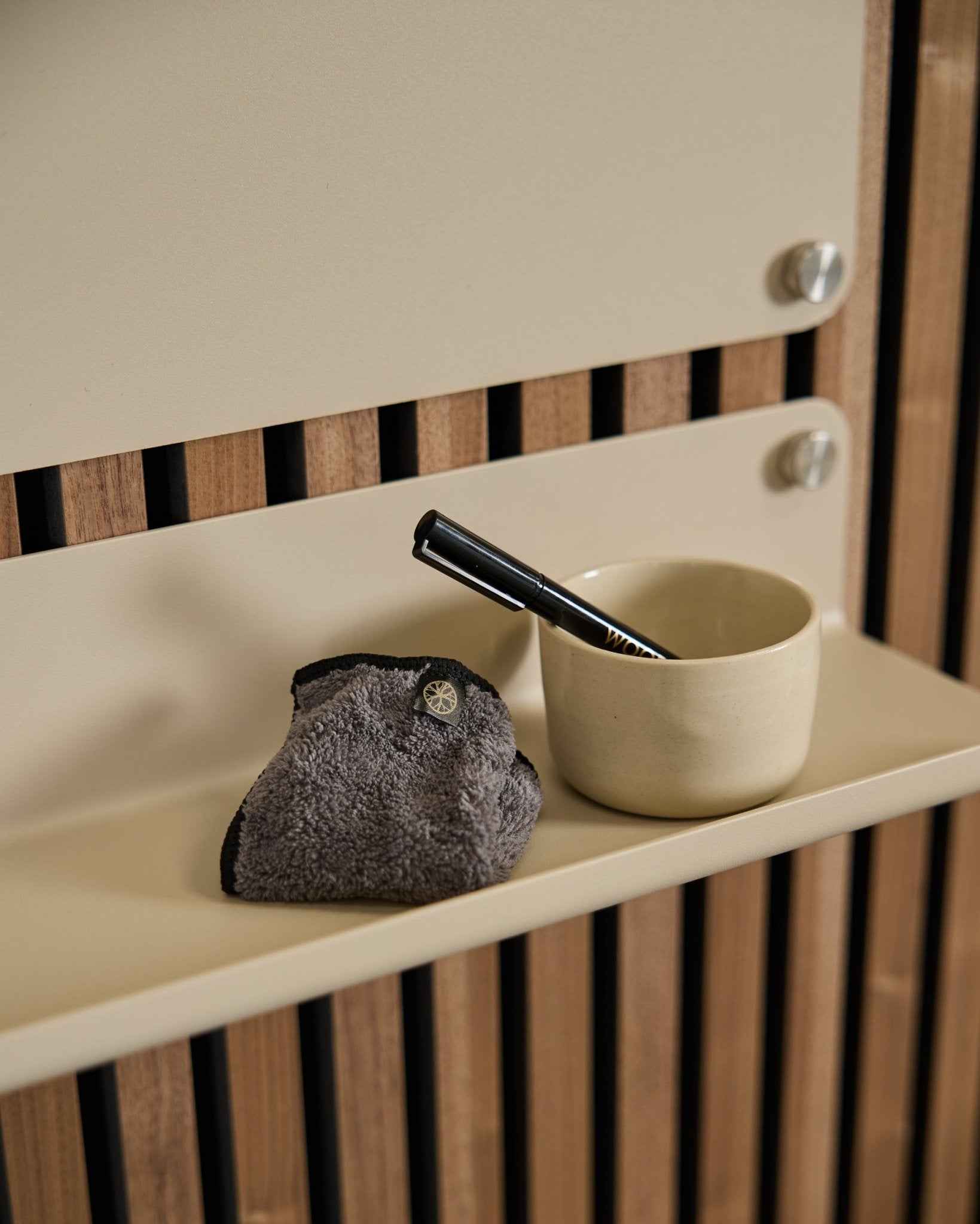 WoodUpp Norr Blackboard-settet inkluderer en small beige kopp, børste med black håndtak og rengjøringsklut på en beige hylle med nordisk akustisk trepanel.