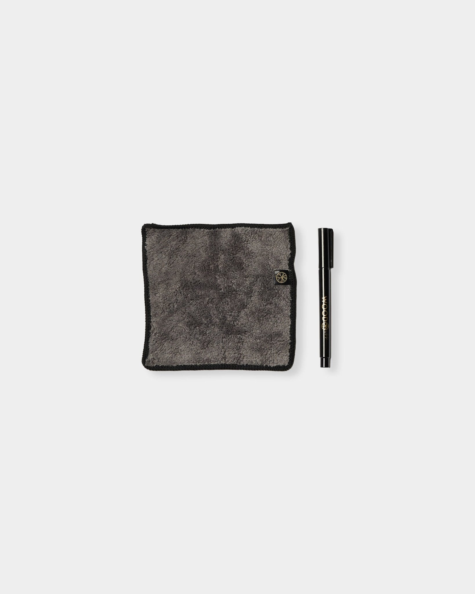 Norr Blackboard-settet fra WoodUpp består av en grå mikrofiberklut med black kanter og en tusj med krittblekk, laget for bruk på magnetiske akustikkpaneler.