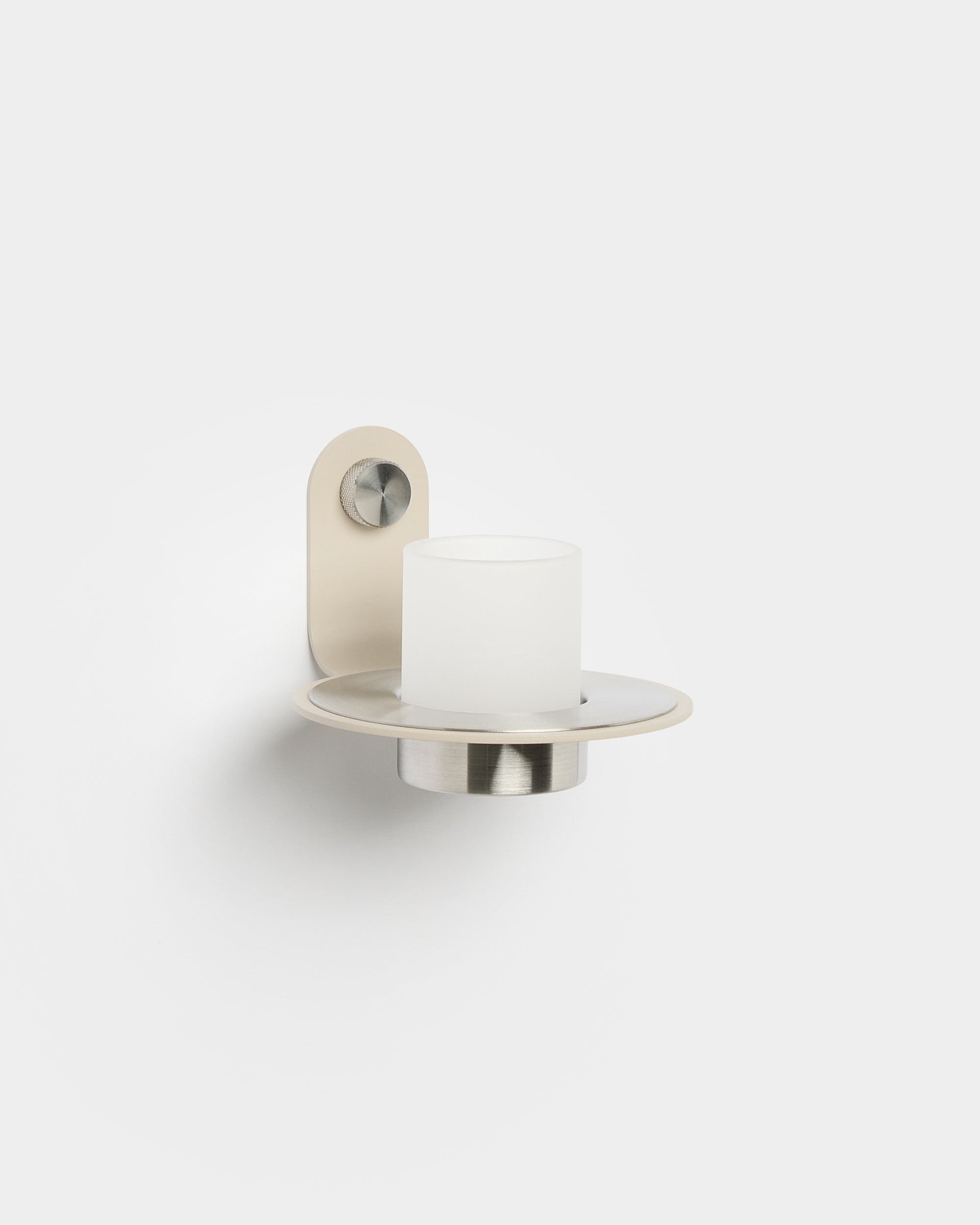 Norr Candle Holder fra WoodUpp, med en base i beige rustfritt steel, plassert på en Akupanel Akustikkpanel for en moderne nordisk detalj.