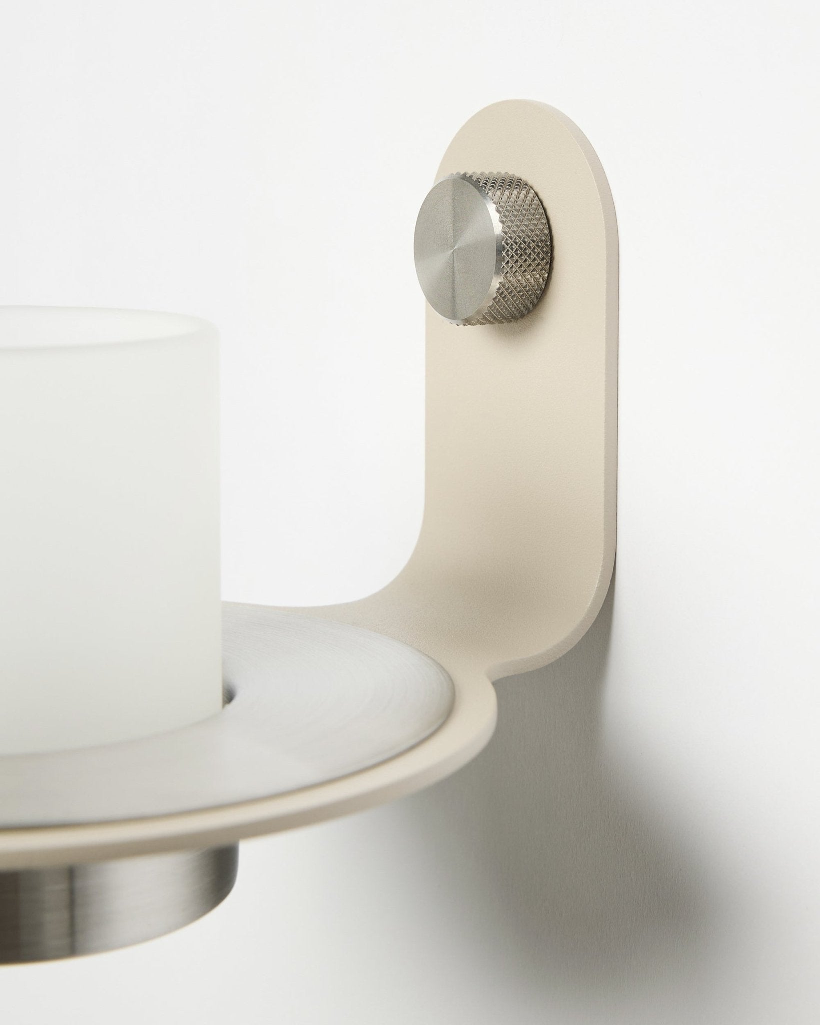 Minimalistisk Norr Candle Holder i beige og rustfritt steel fra WoodUpp, vist som tilbehør til Akupanel akustiske spilepaneler.