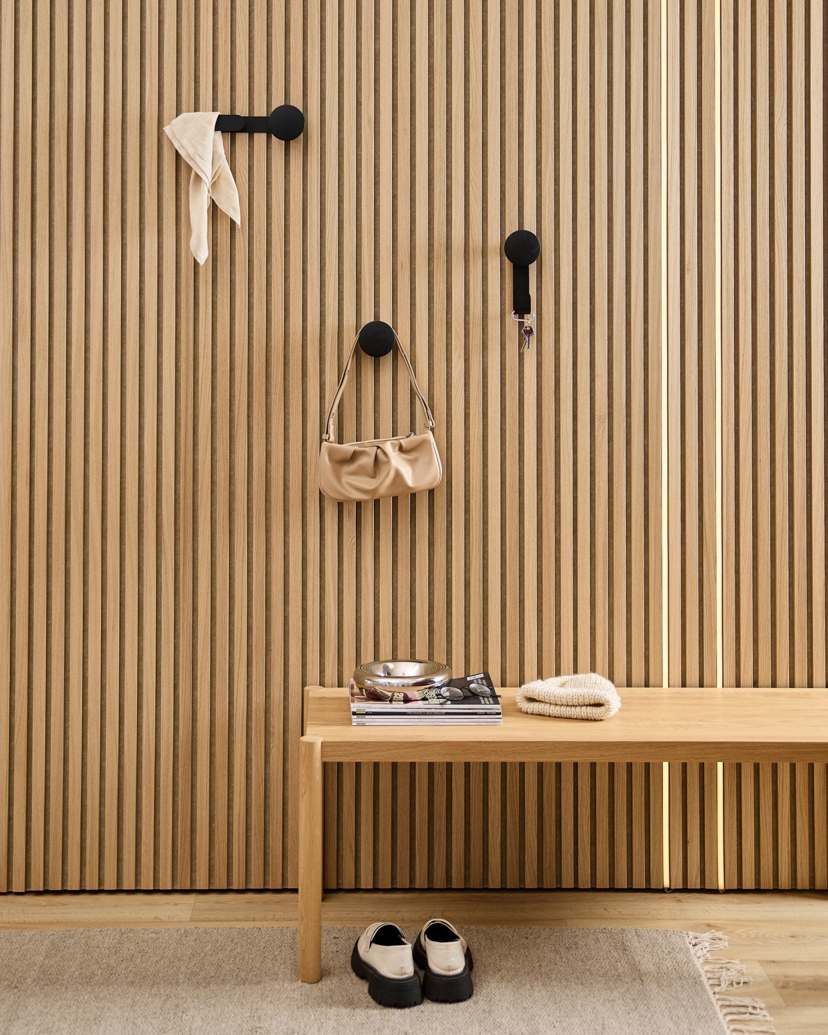Minimalistisk entré med en WoodUpp Linn Horizontal Hanger i Black Oak med black kroker, trebænk, sko, bøker og et fat. Nordisk stil.