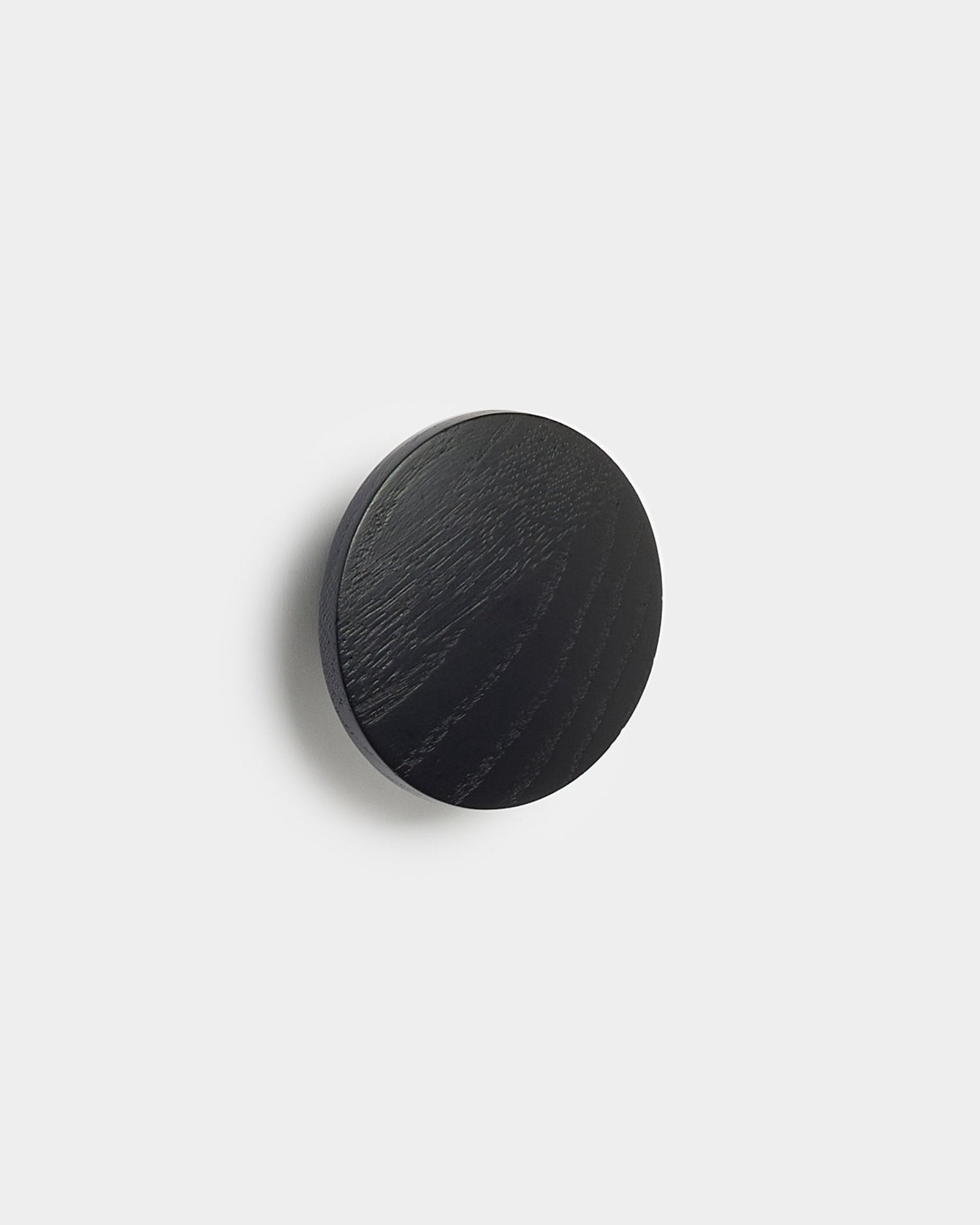 Linn | Single Hanger i black oak fra WoodUpp, et rundt tilbehør til Akupanel akustikkpaneler, vist mot en enkel hvit bakgrunn.
