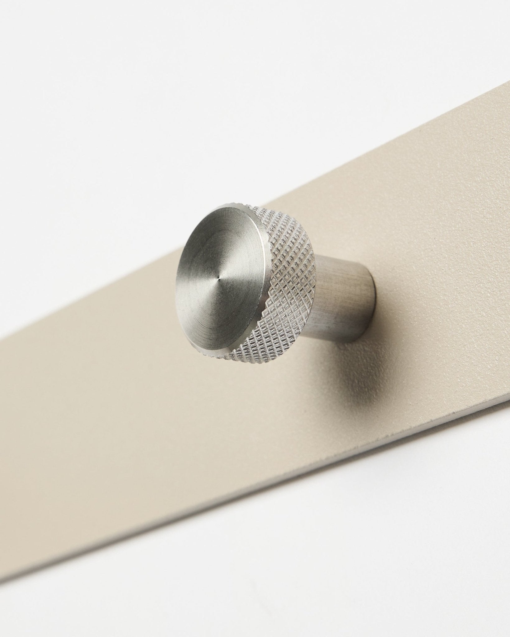 Norr knaggrekke i beige og rustfritt steel fra WoodUpp, tilbehør til Akupanel-kolleksjonen, vist i nærbilde mot hvit bakgrunn.