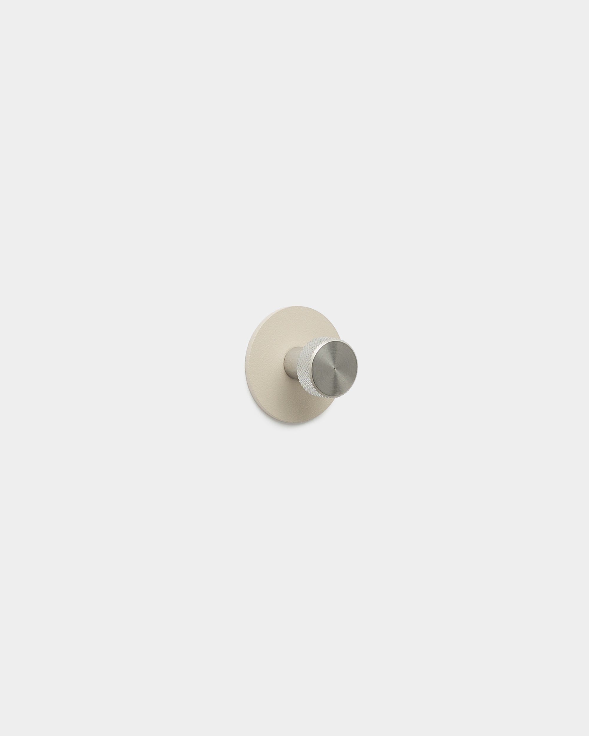 WoodUpp Norr knagg i beige og rustfritt steel med en minimalistisk tapp og rund base, laget av pulverlakkert steel, en del av WoodUpp-tilbehøret.