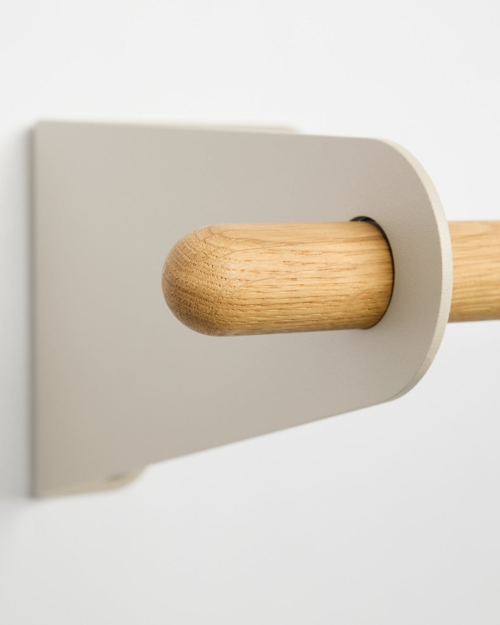 Nærbilde av WoodUpp Linn knaggrekke i beige (75,9 cm), en stang i massiv eik med minimalistisk brakett, montert på en hvit vegg og med nordisk design.