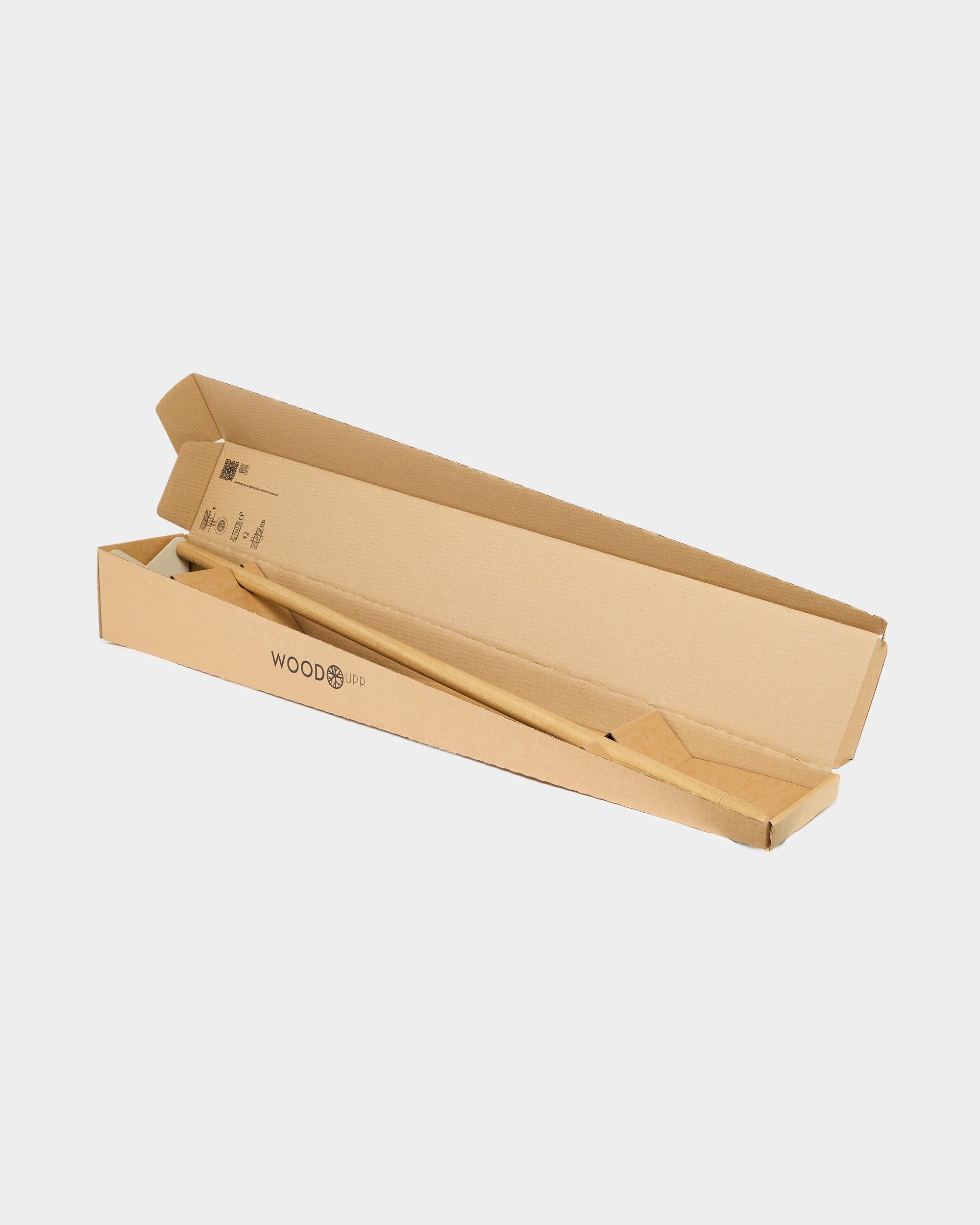 A long, light brown cardboard box partially opened to reveal a wooden acoustic panel inside, with WOODBOO branding on the exterior.