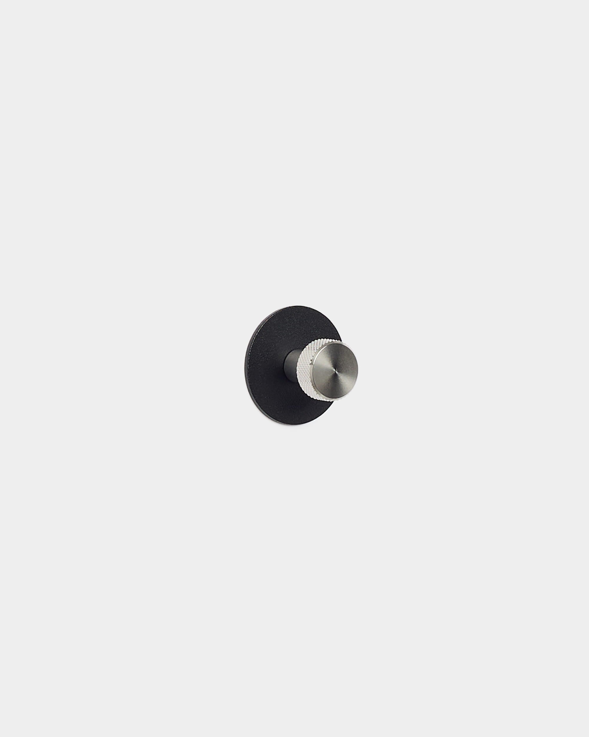 Norr knagg fra WoodUpp har en rund base i black og sølvfarget tapp, utformet som et tilbehør til Akupanel akustikkpaneler – passer godt i minimalistiske, nordiske rom.