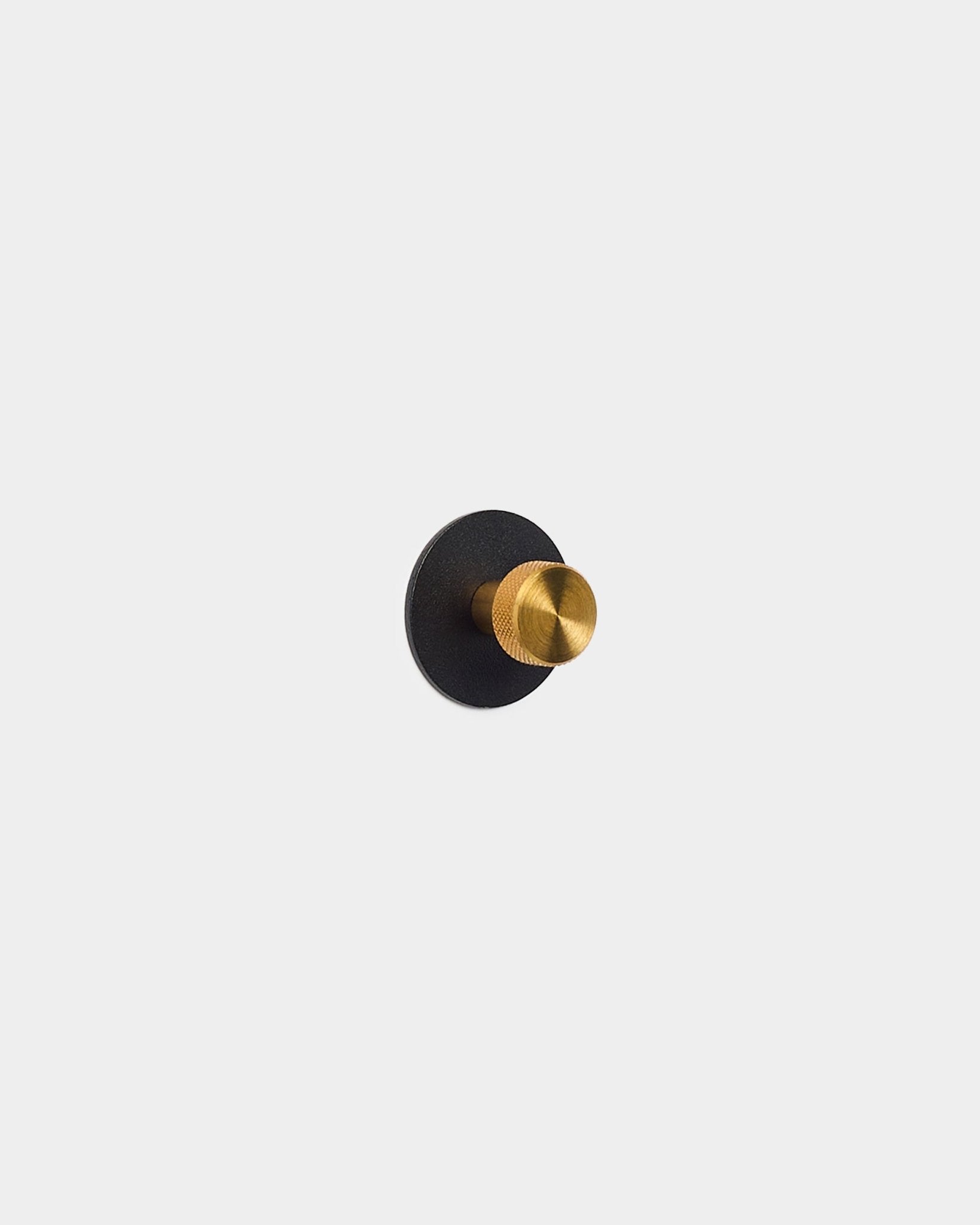 Gullfarget knagg montert på en black Akupanel Akustikkpanel-base, laget av pulverlakkert steel fra WoodUpp.
