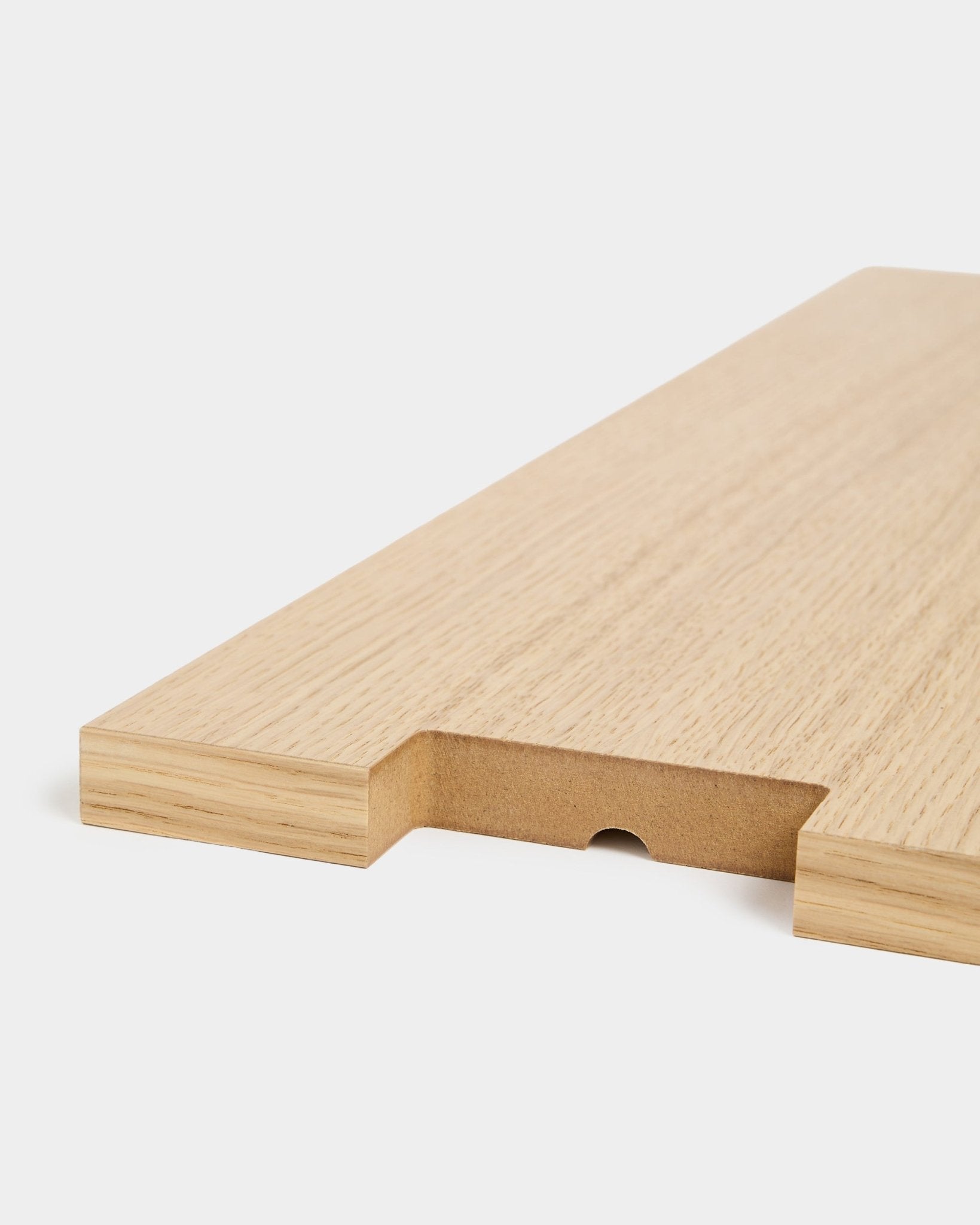 Lova | Wood Shelf BM2 i eikefiner fra WoodUpp, 65,8 x 20 cm, vist i nærbilde med et utskåret parti og et halvsirkelformet spor mot hvit bakgrunn.