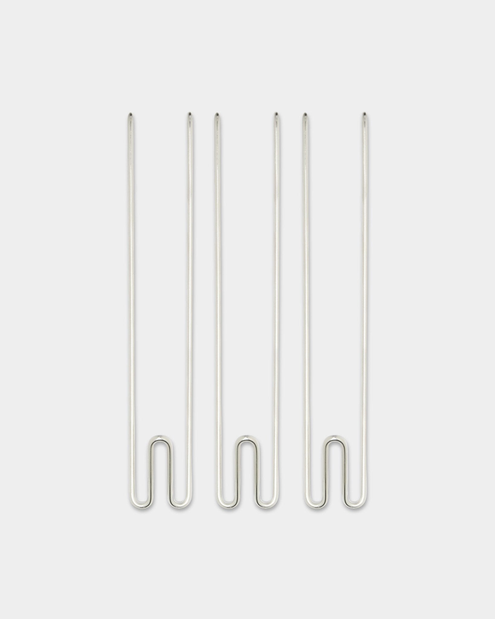 Tre Alva Wire Hook / BM1-tilbehør fra WoodUpp, lange kroker i rustfritt steel arrangert vertikalt mot en enkel hvit bakgrunn.
