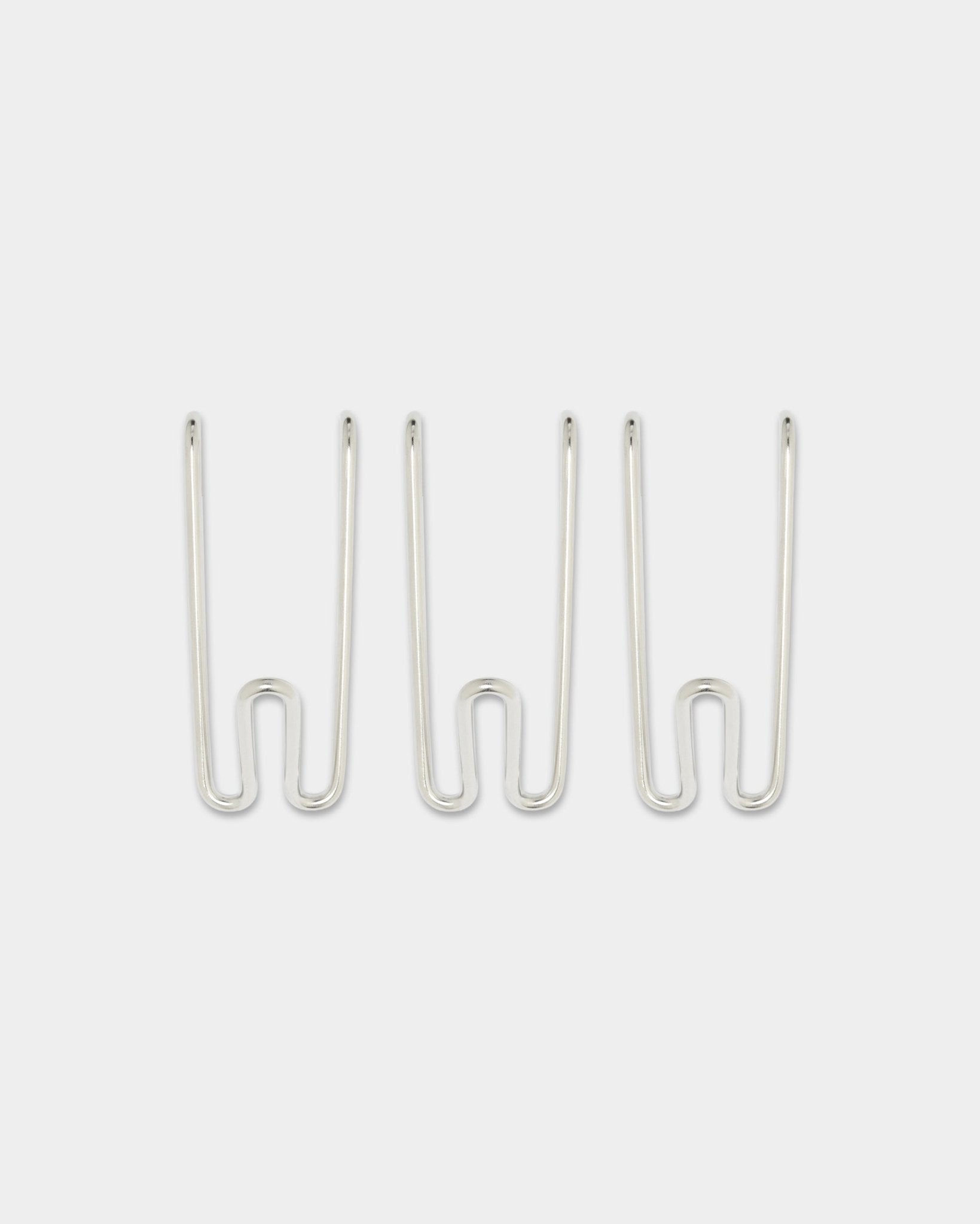 Tre Alva Wire Hooks BM1, kort, i rustfritt steel fra WoodUpps CREATE-kolleksjon, jevnt fordelt mot en enkel hvit bakgrunn.