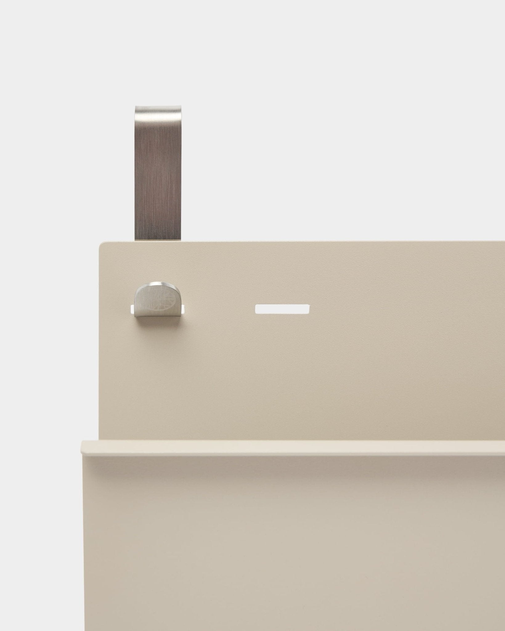 Nærbilde av WoodUpp Nell Magazine Storage i beige, pulverlakkert steel, med hylle, spor, bolt og buet håndtak; fungerer som romdeler eller magasinholder.