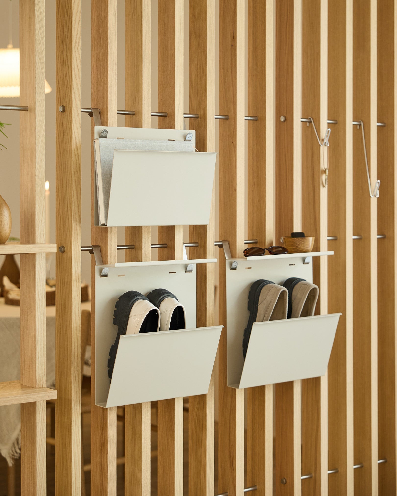 Nell Magazine Storage fra WoodUpp i beige er festet til en vertical romdeler og gir ryddig oppbevaring til magasiner og small gjenstander.