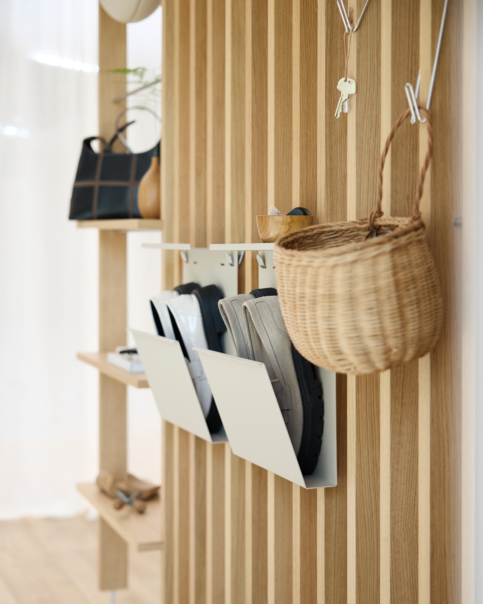 Moderne entré med WoodUpps beige Nell Shoe Storage, Akupanel akustiske trepanelvegger, veggkroker, en hengende kurv og en hylle med dekorative gjenstander.