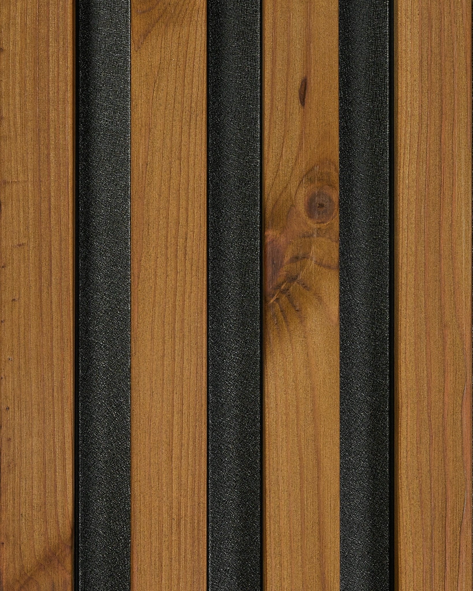 Nærbilde av prøve på WoodUpp Aluwood fasadepanel i oljet brown finish (45.7 x 27 cm), som fremhever natural wood trestruktur og black teksturerte spiler.