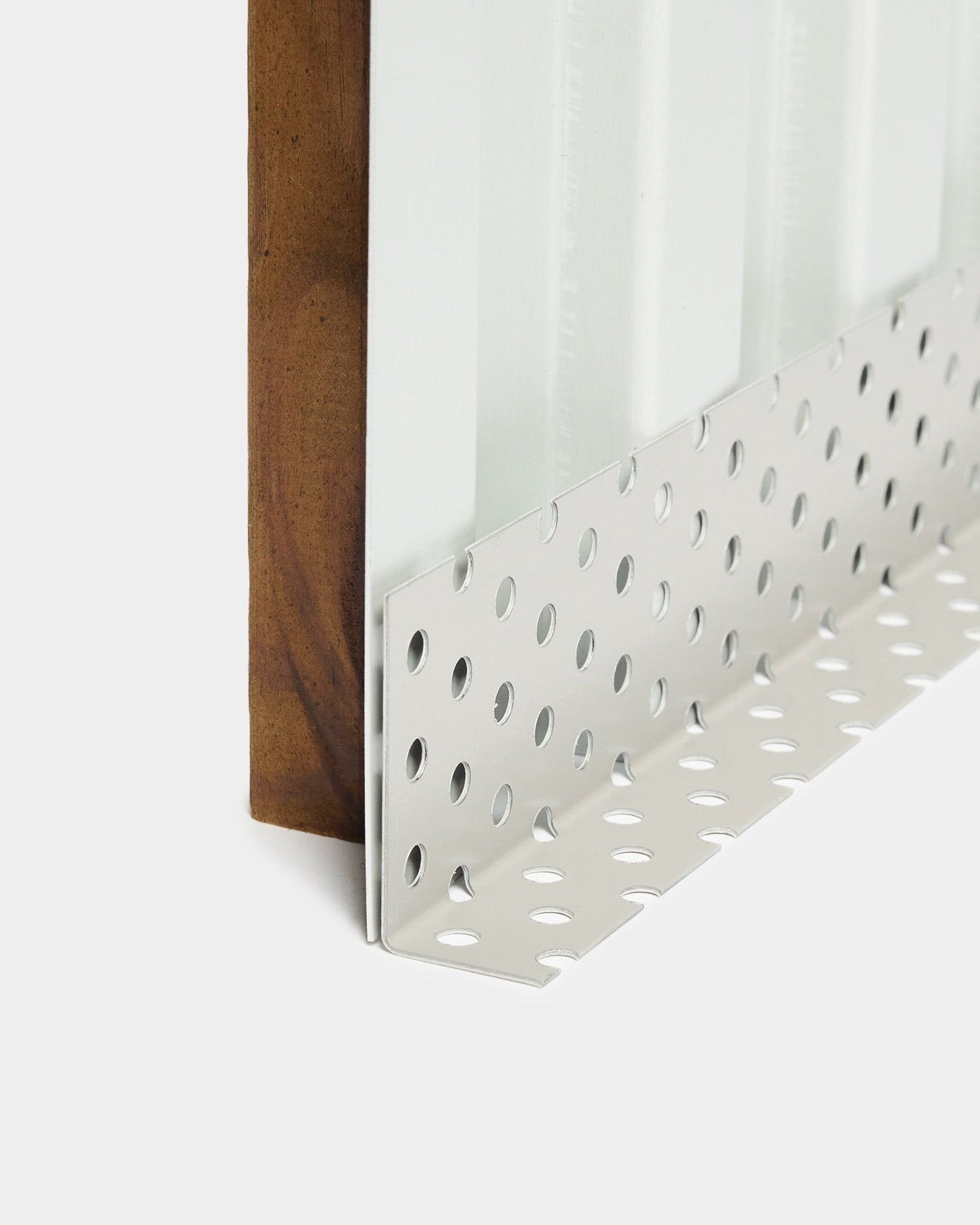 Nærbilde av tilbehør til Aluwood fasadepanel Montering: hjørneprofil i metall med large runde perforeringer, utformet for ventilerte hulrom, lengde 240 cm.
