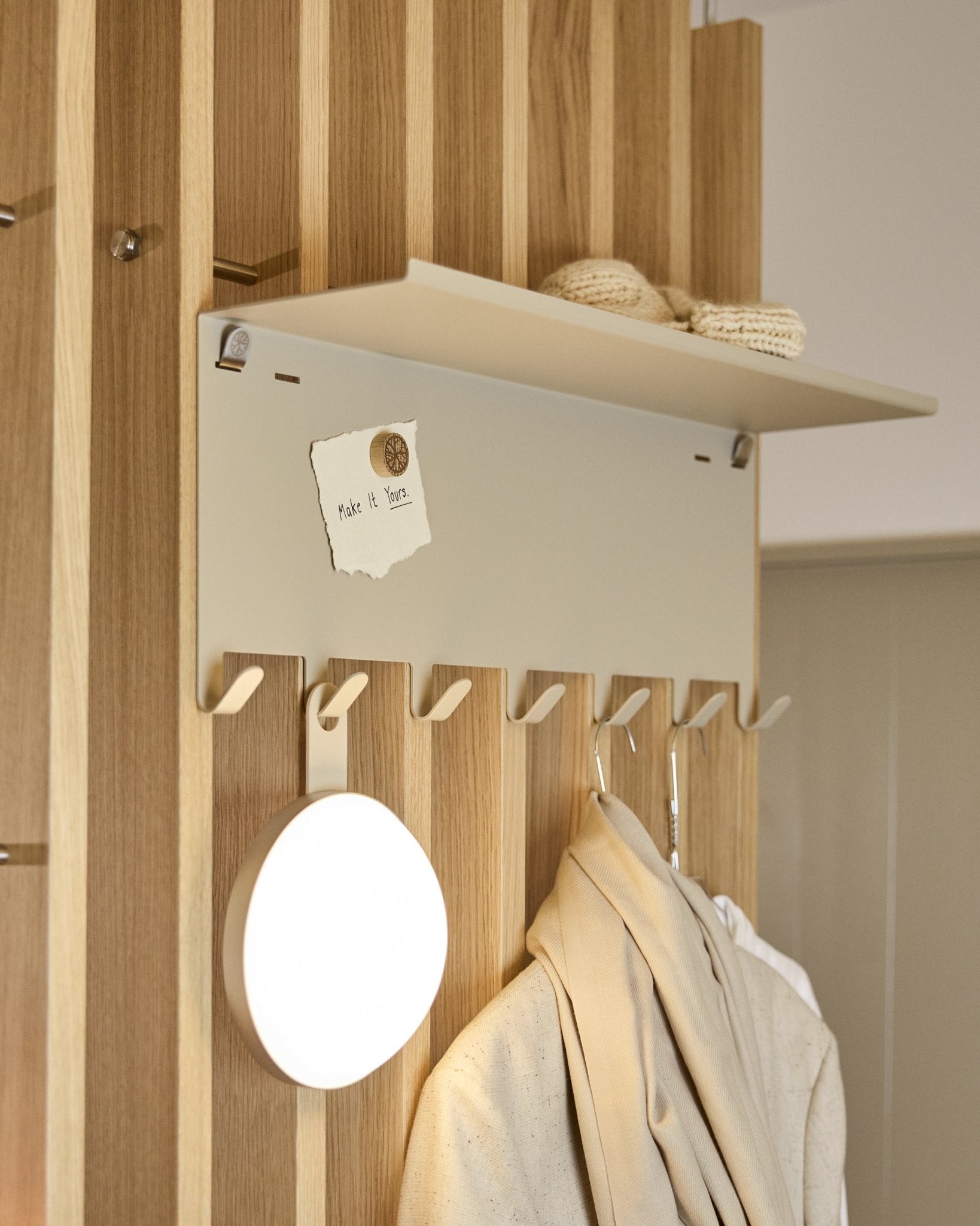WoodUpp Nell | knaggrekke BM1 i beige (63,5 x 24 cm), med steel kroker og en hylle med strikkeplagg og en lapp med teksten embrace BM1.