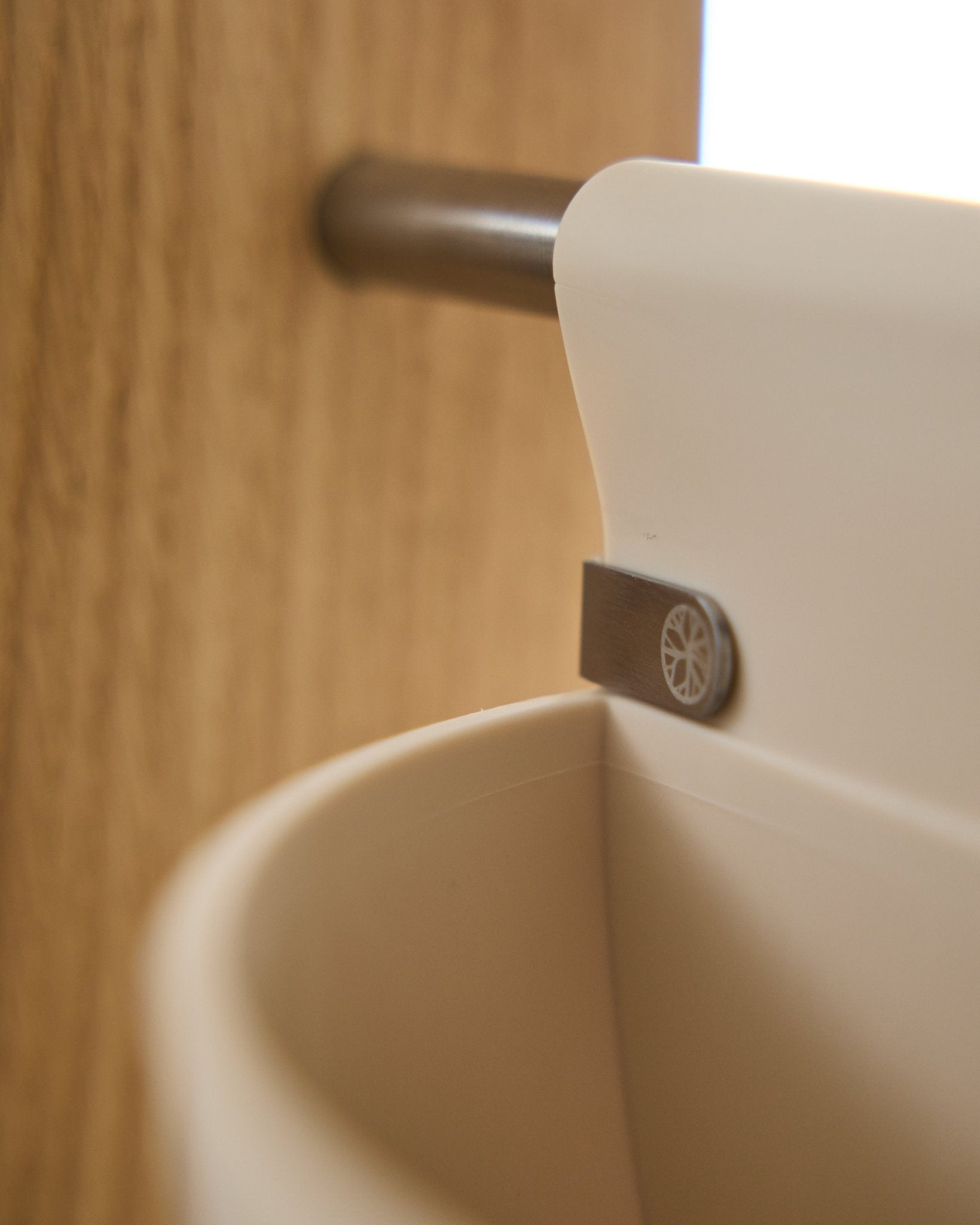 Nærbilde av Gro | Soft Pocket / BM2 (4 l) i lys beige fra WoodUpp, hengende på en metallstang montert på tre; uskarp bakgrunn. Nordisk akustikktilbehør.