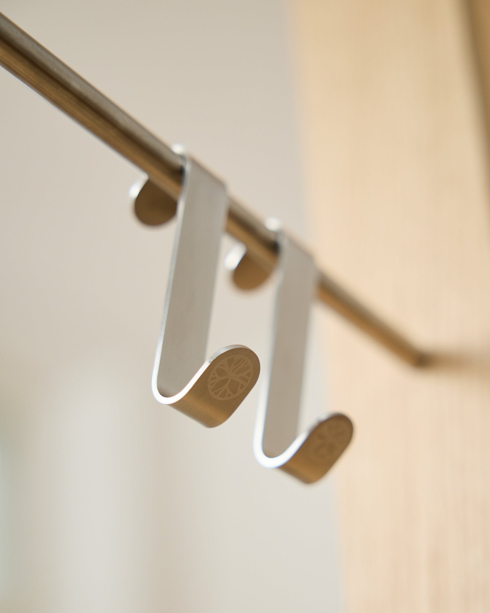 Alva S-krok BM1  BM2 fra WoodUpp, to kroker i rustfritt steel med graverte flate ender, utformet for oppheng av tilbehør på Akupanel horizontal stenger.